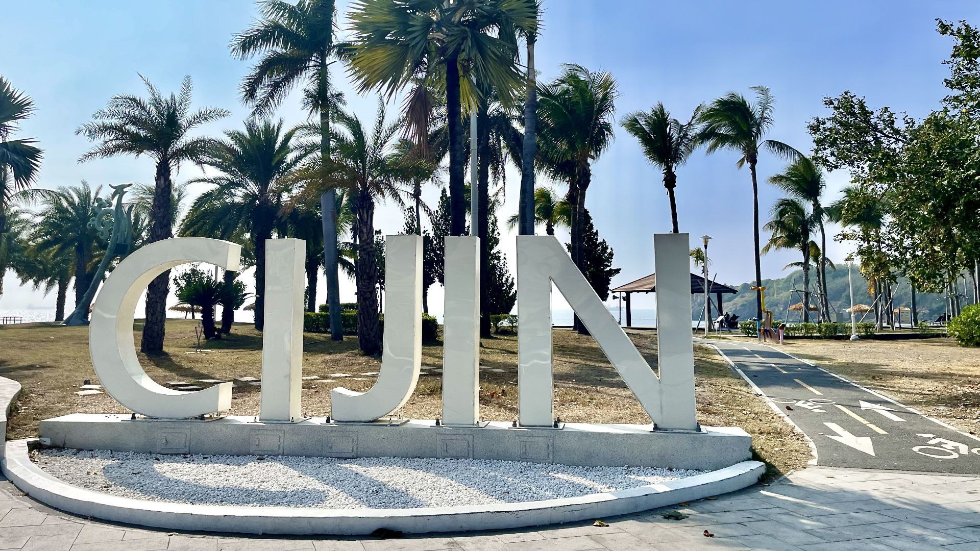 Cijin Island sign, with palm trees in the background.