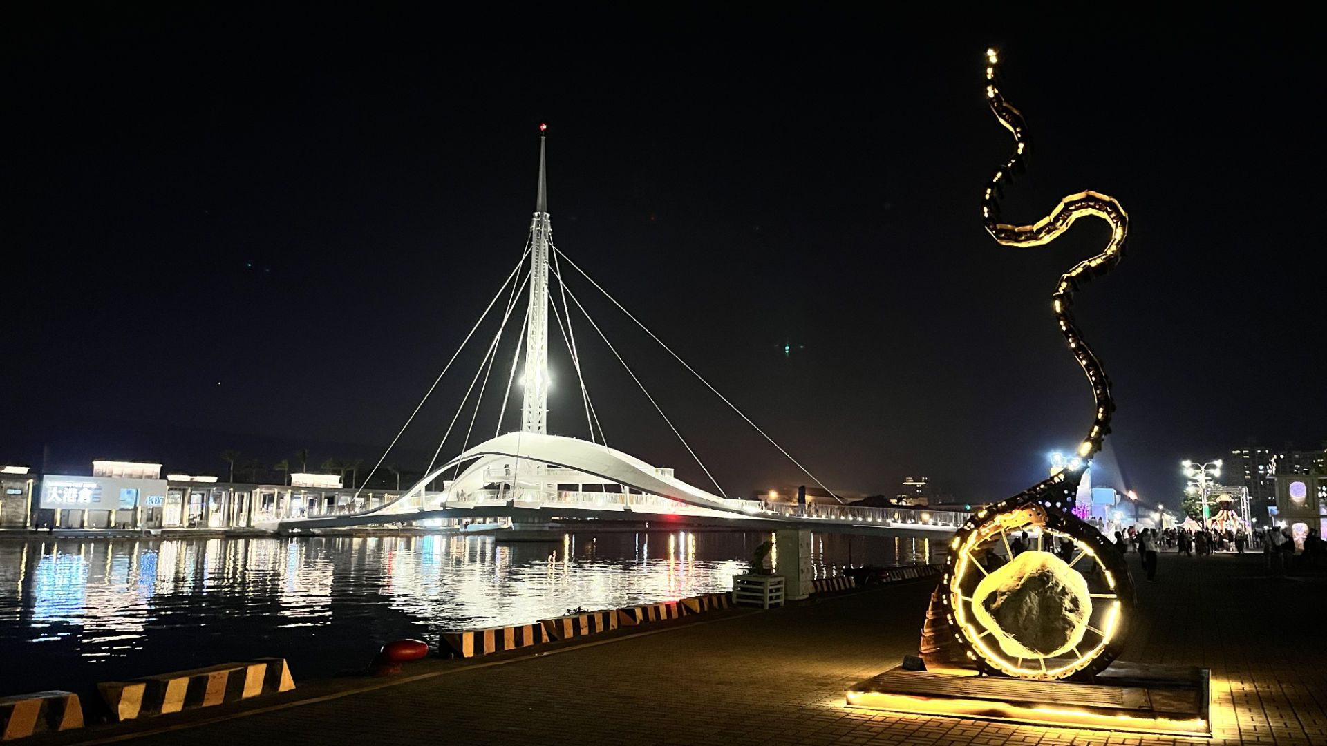 Great Harbour Bridge illuminated at night, with an illuminated outdoor sculpture in the foreground.