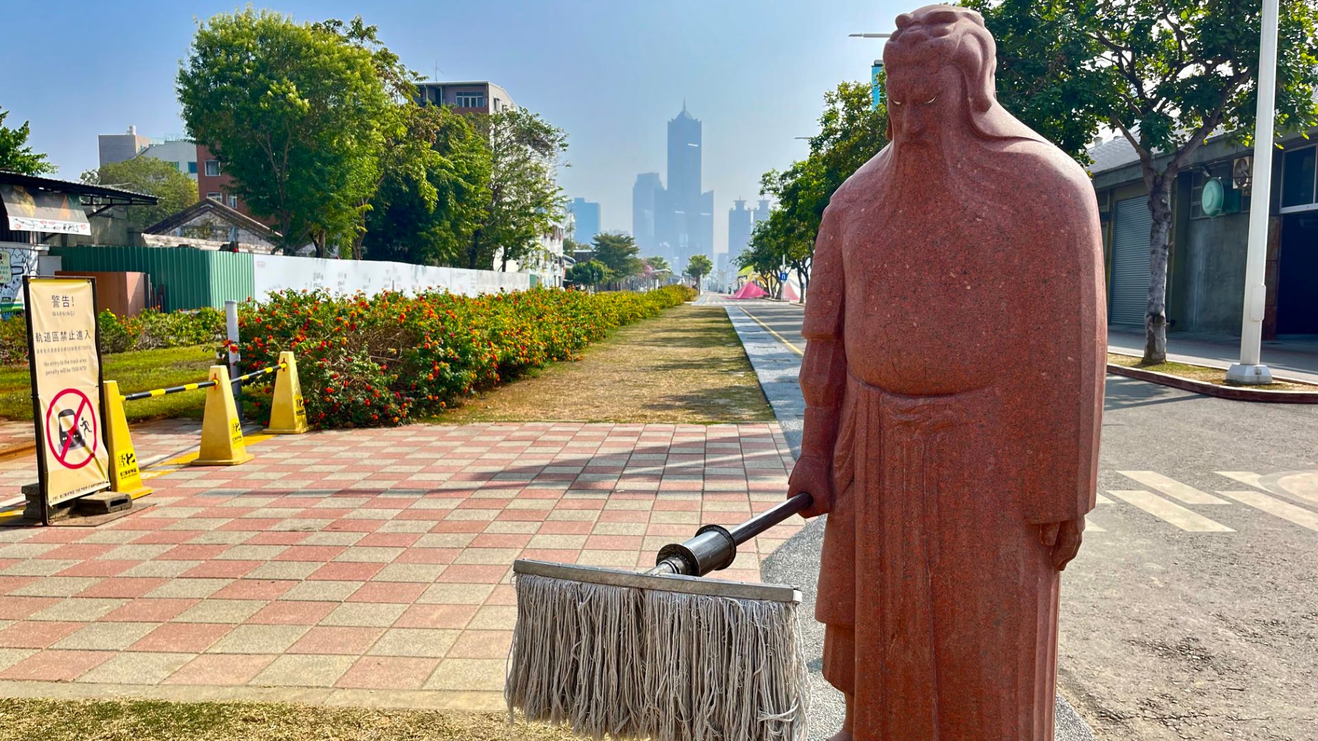 Grumpy-looking statue holding a broom.