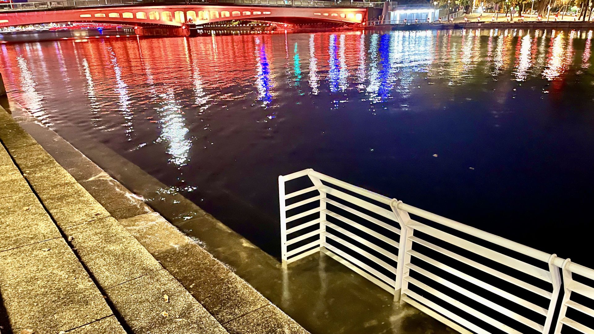 A high tide laps across concrete steps on the edge of Love River.