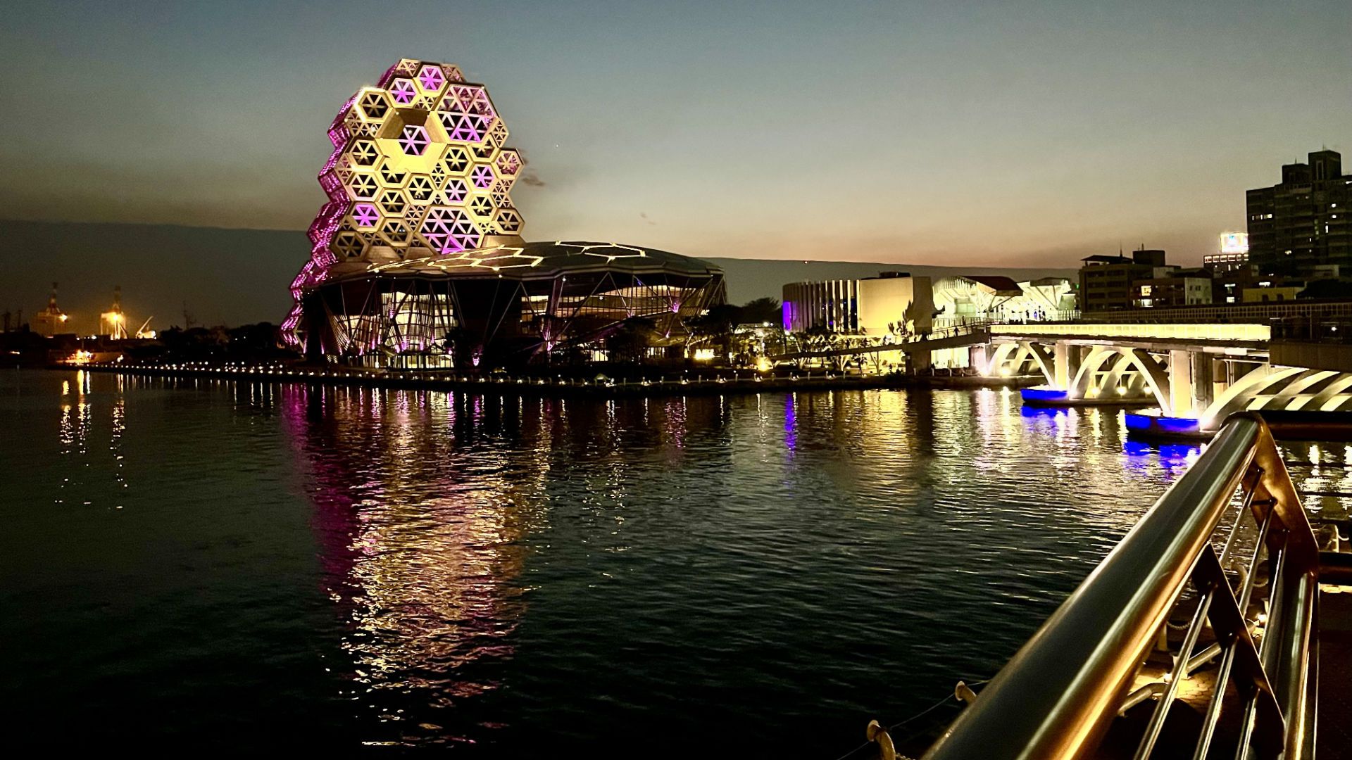 Evening photo of Kaohsiung Music Center from across the mouth of Love River.