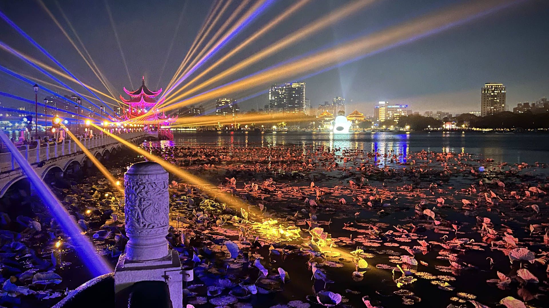 Multi-colored laser lights projecting across Lotus Pond from the Wuli Pavilion.