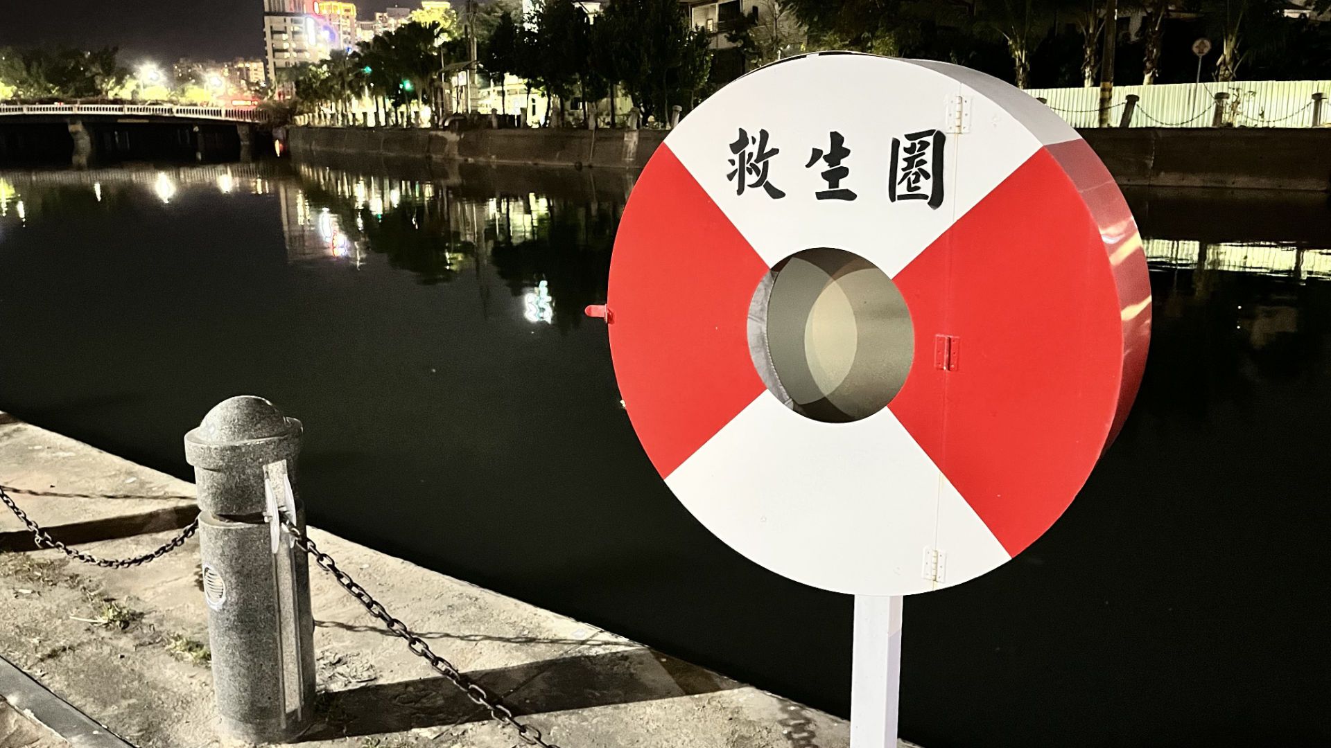 A round, red and white cabinet with the word 救生圈 painted on it.