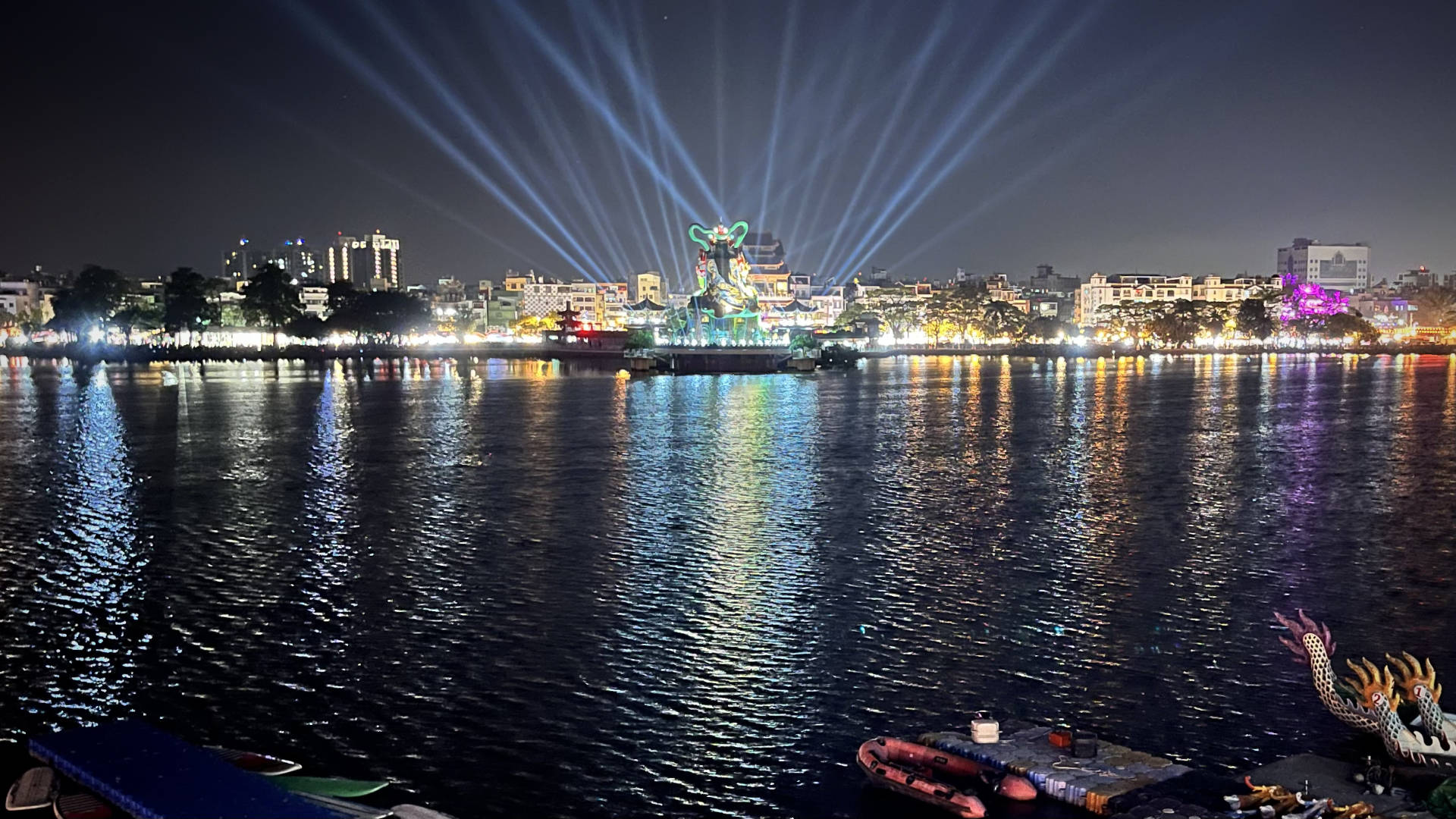 Laser lights projecting up into the sky from behind the Xuanwu statue, across Lotus Pond.