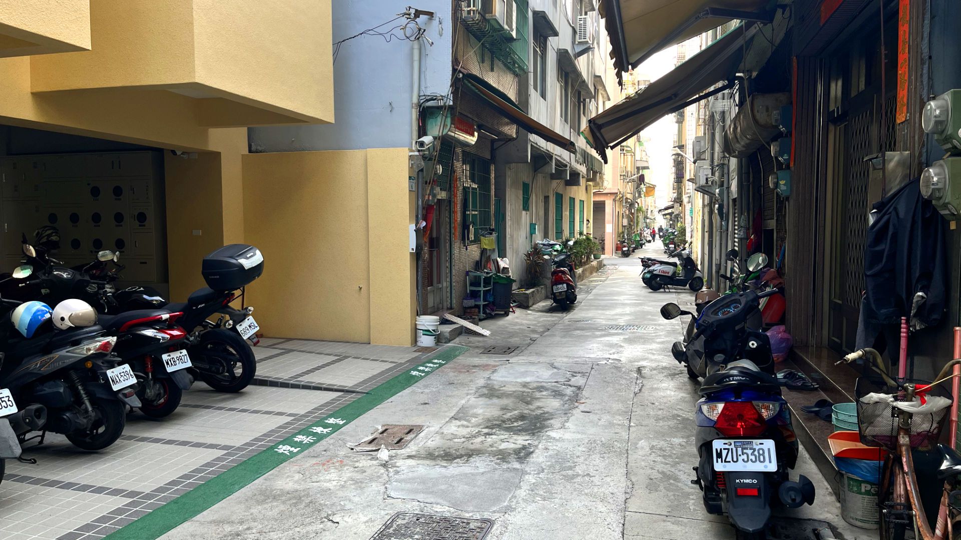 Scooters parked on private parks off an alleyway.