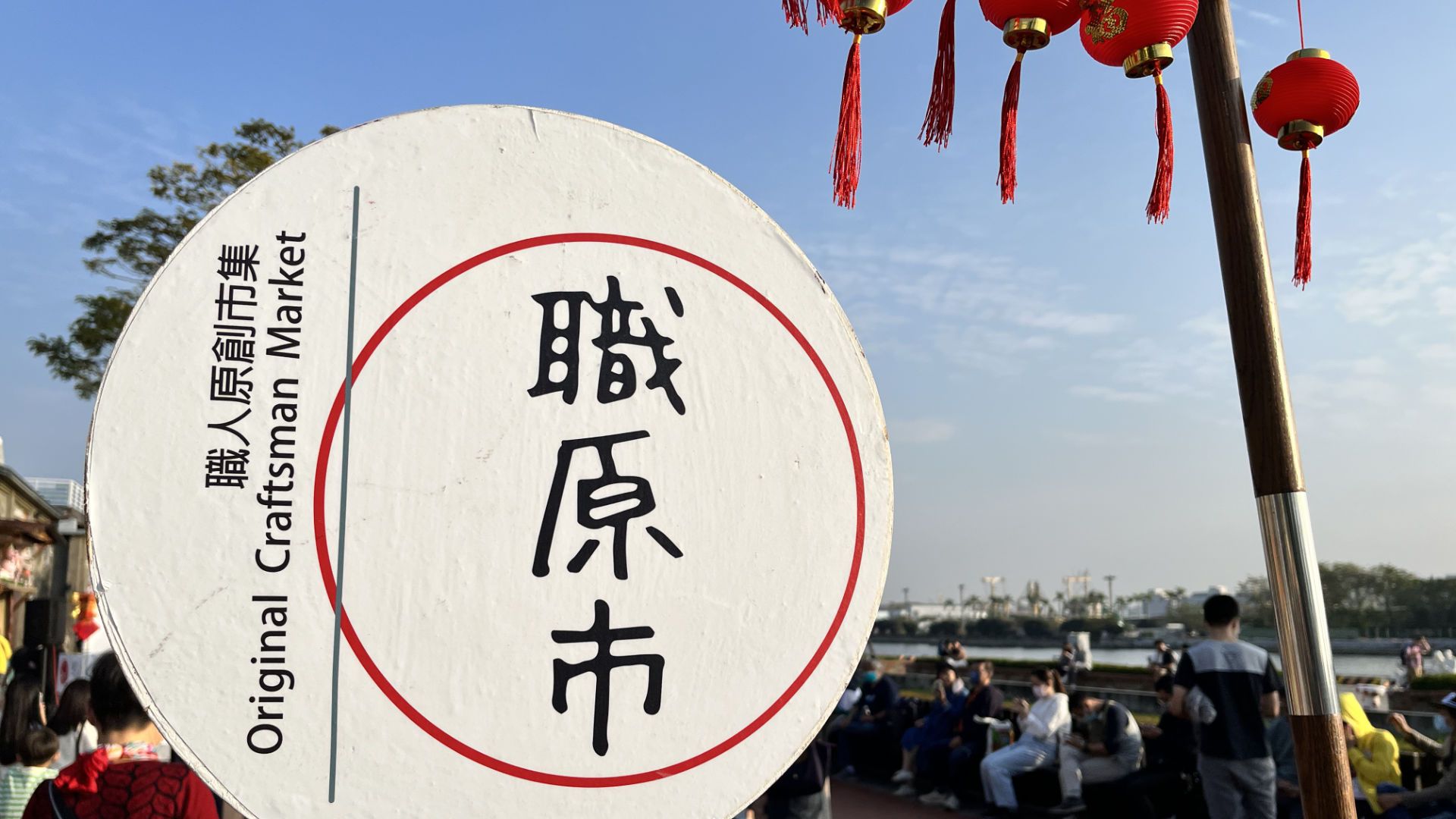 A sign that says ‘Original Craftsman Market’, with Chinese lanterns hanging above.