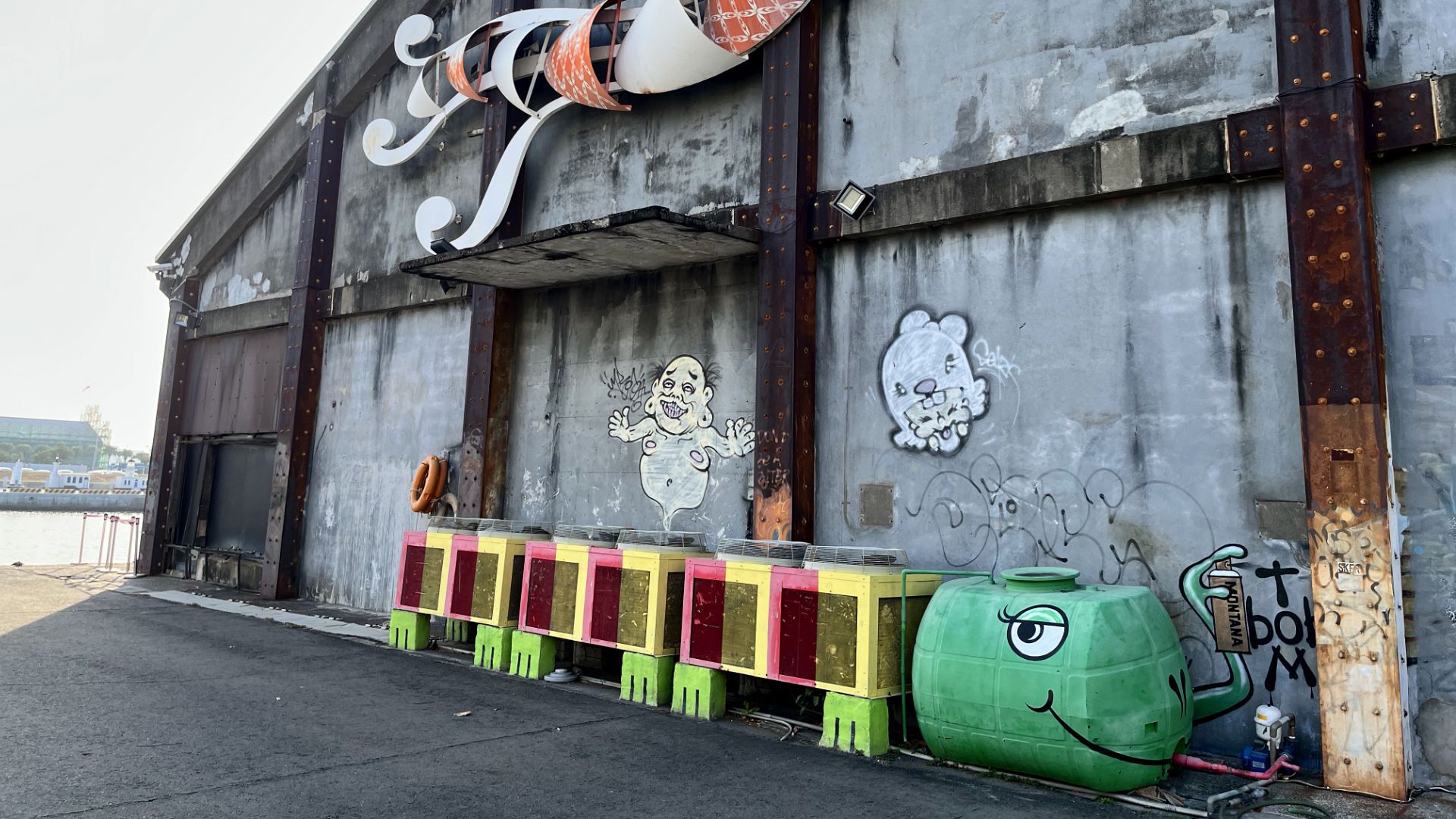 Air conditioning units outside a warehouse, painted to look like a multi-legged creature.