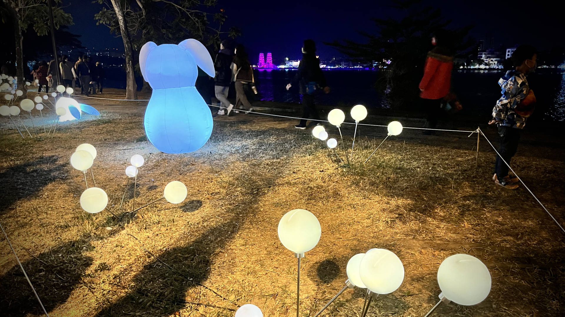 Illuminated orbs and an inflatable rabbit in the foreground, with Lotus Pond and the Dragon and Tiger Pagodas in the distance.