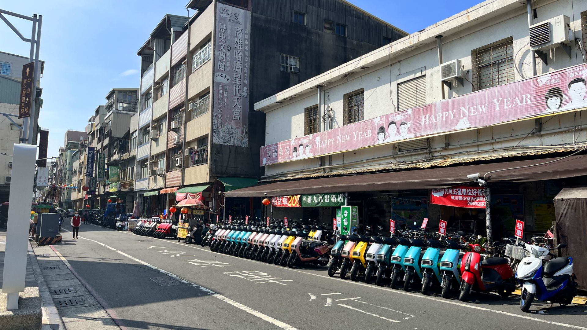 A row of approximately 40 scooters on the side of the street.