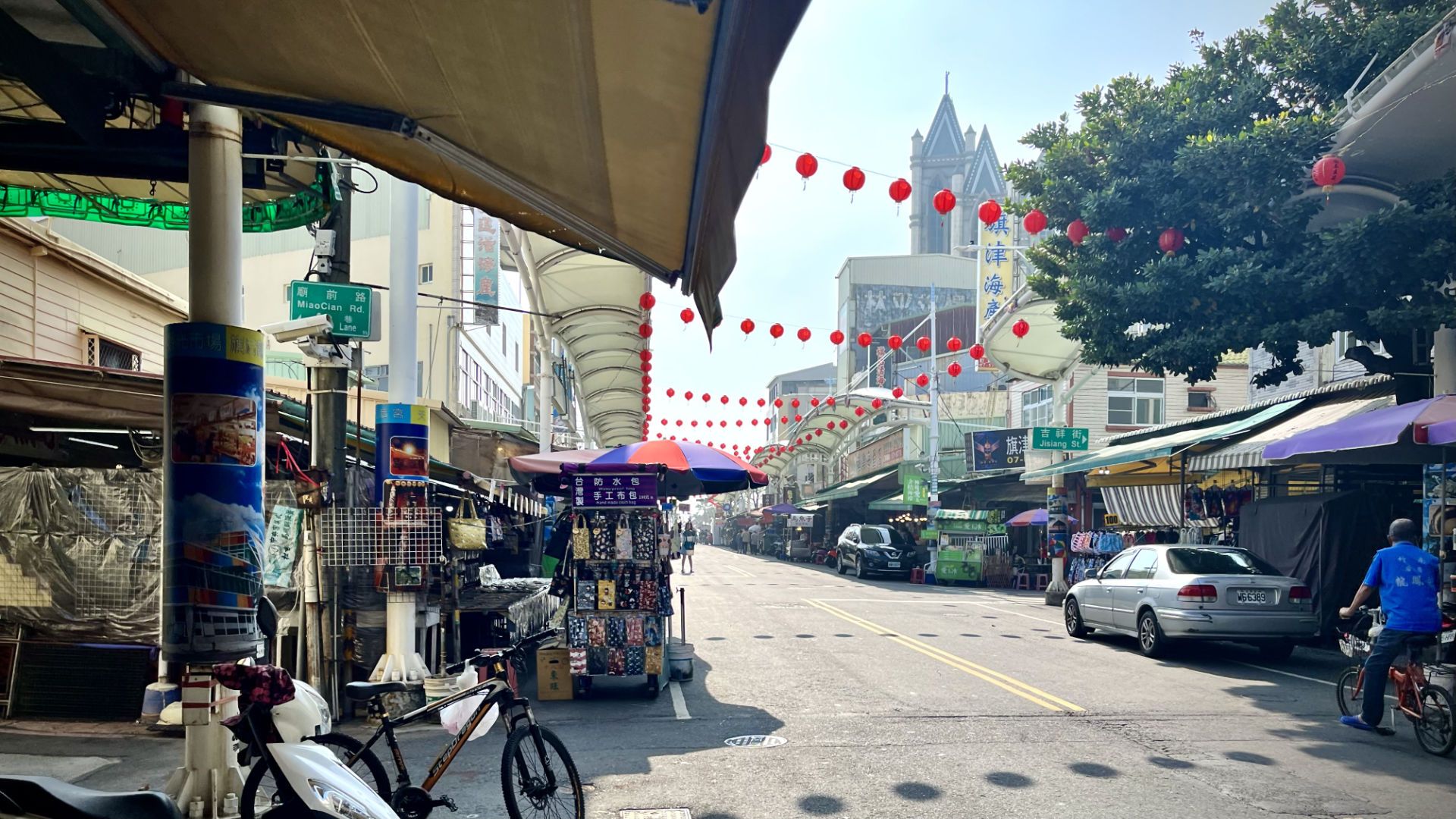 The main street on Cijin Island, with red lanterns hanging above the road and stalls and shops on either side.