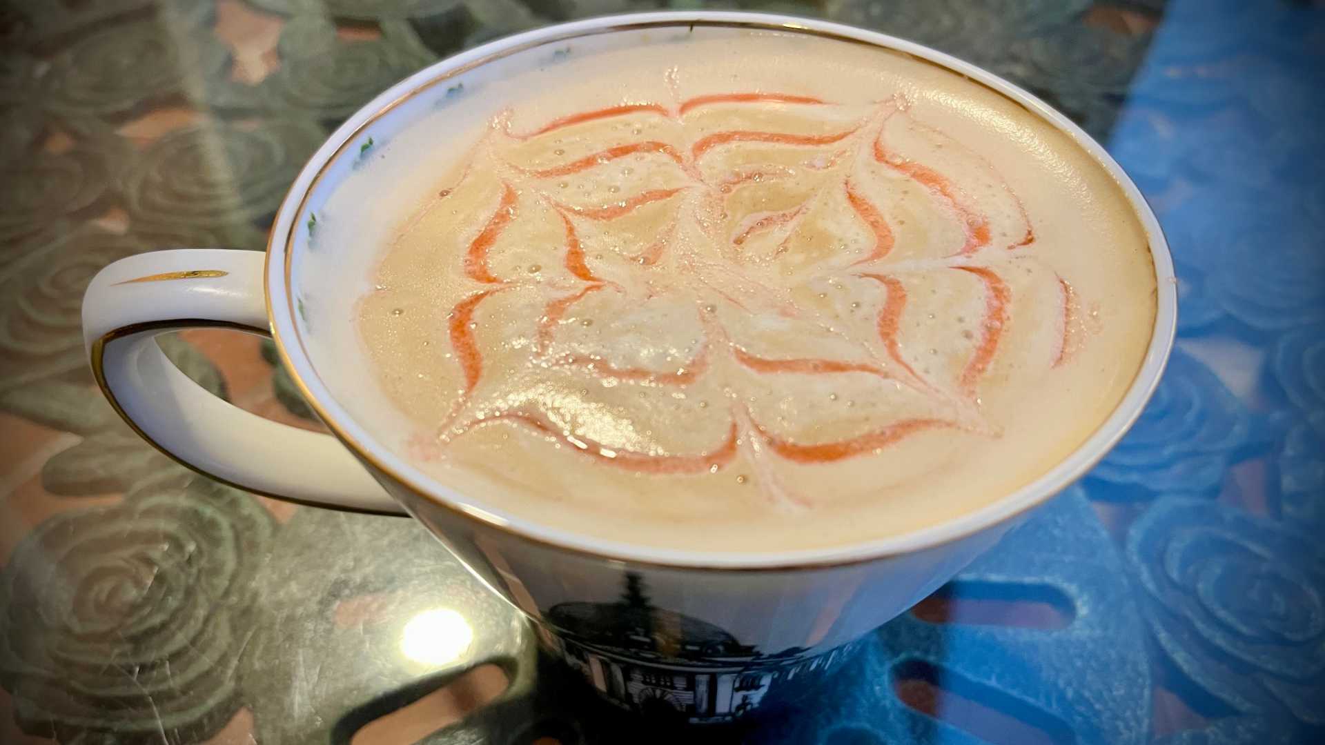 Close-up of a cup of coffee with an intricate pattern in the foam.