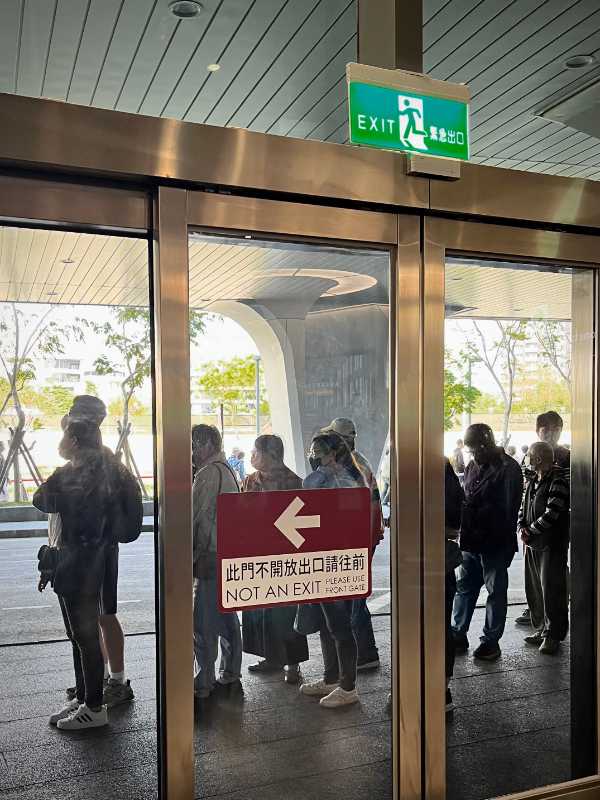 A glass door with an exit sign above, and a second sign on the door that says "not an exit".