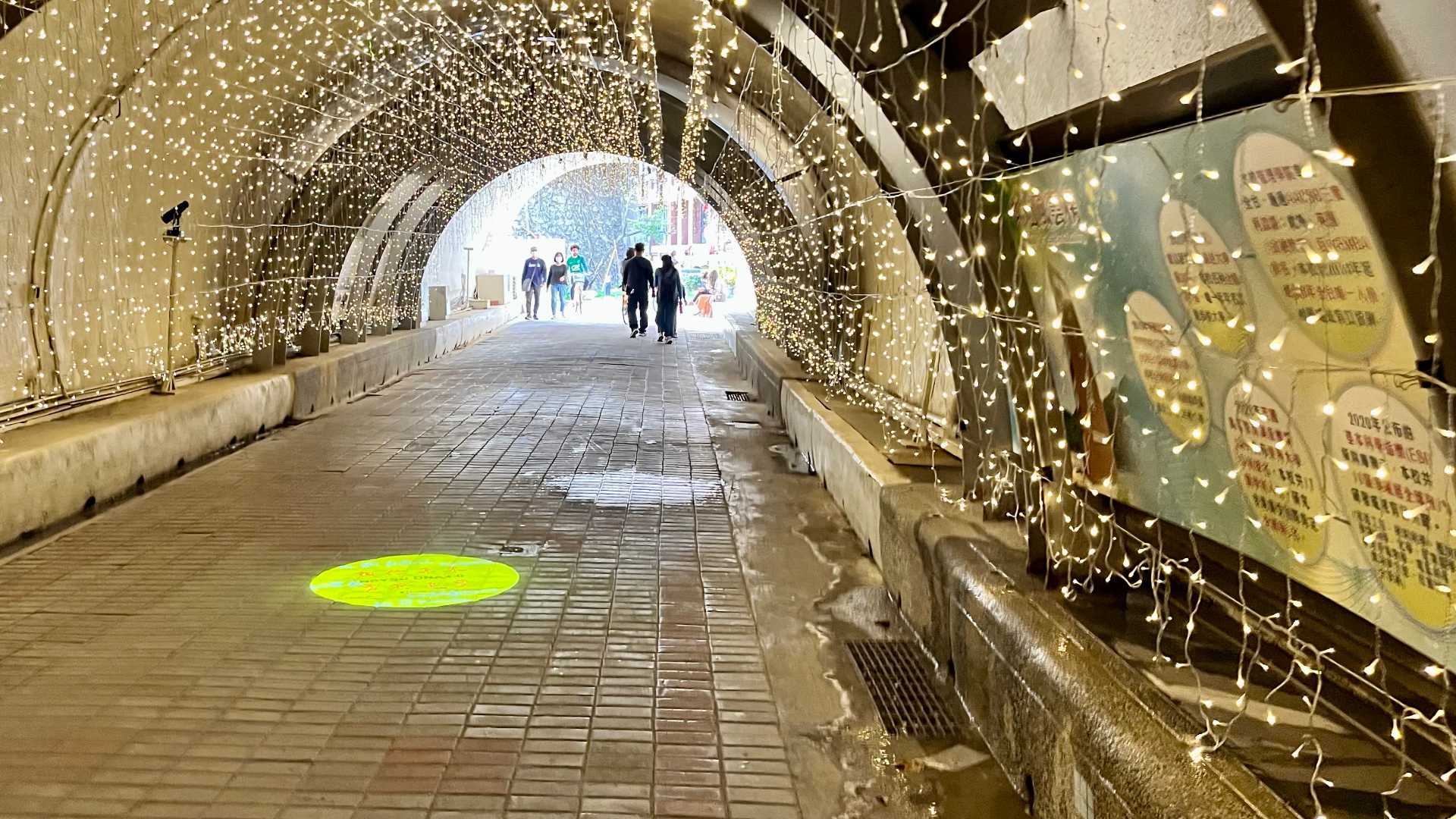 Thousands of fairy lights hanging from the roof and walls of the tunnel, with the tunnel exit visible in the near-distance.