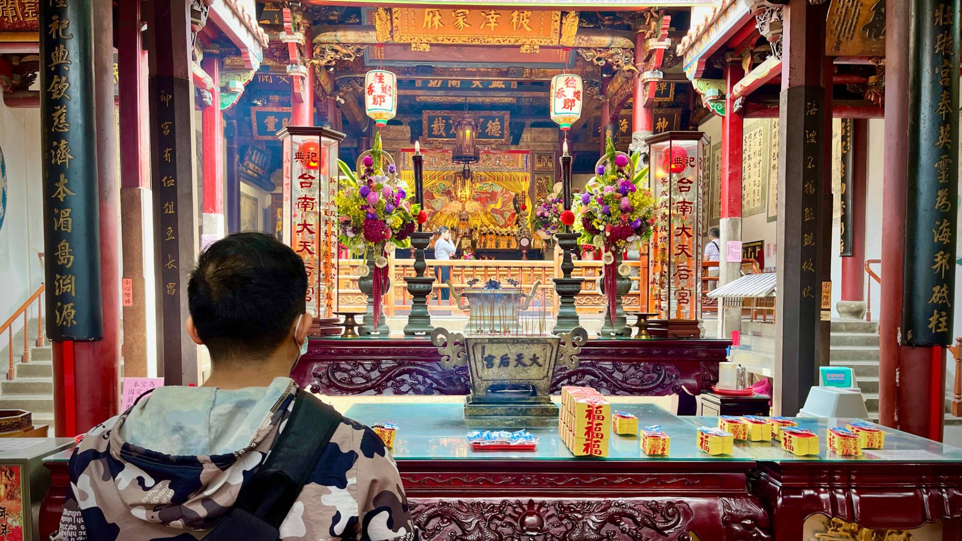 Two people praying inside a temple.