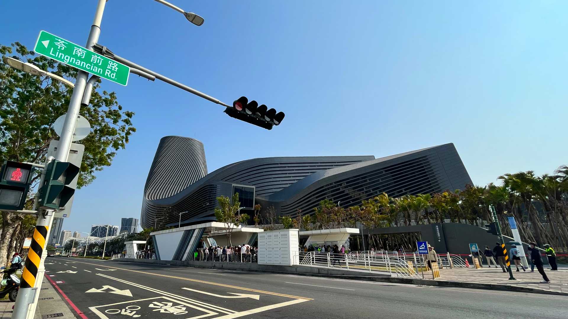 Exterior view of the Kaohsiung Port Cruise Terminal, with hundreds of people waiting at Cruise Terminal station in the foreground.