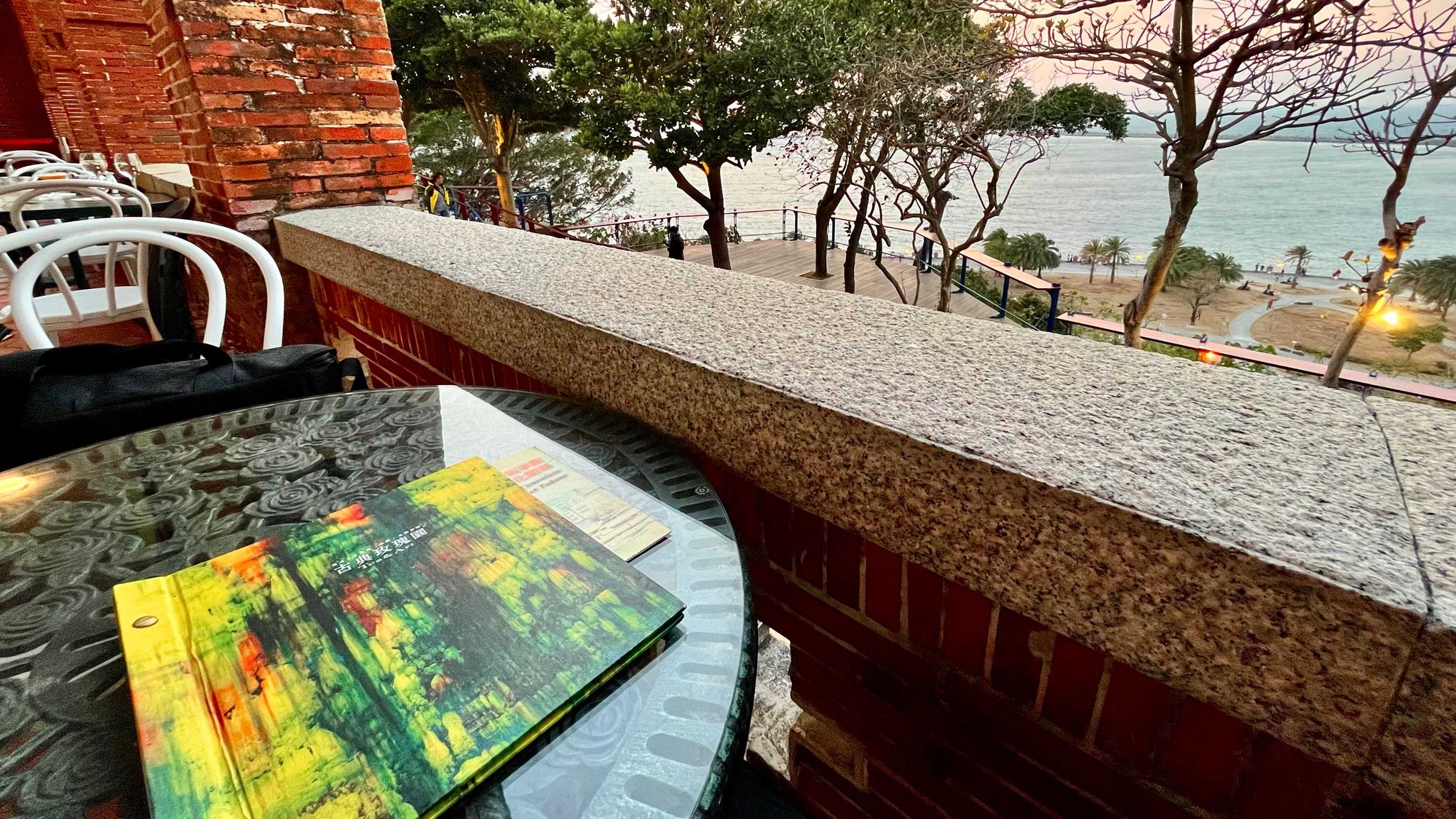 A book on a coffee table, with a view across the water below.