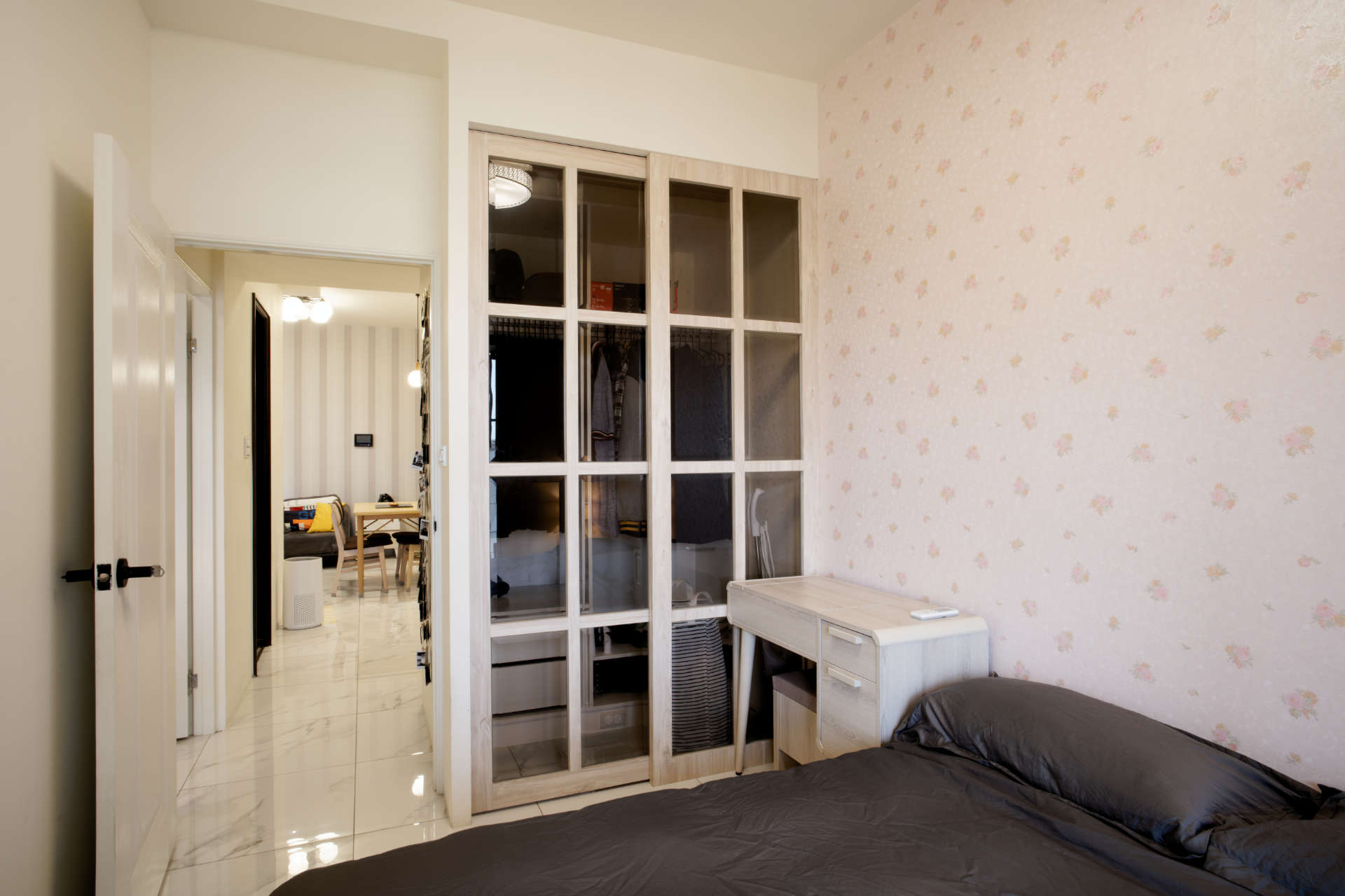 A bedroom with double bed in the foreground, a make-up table, and a glass-panelled wardrobe.