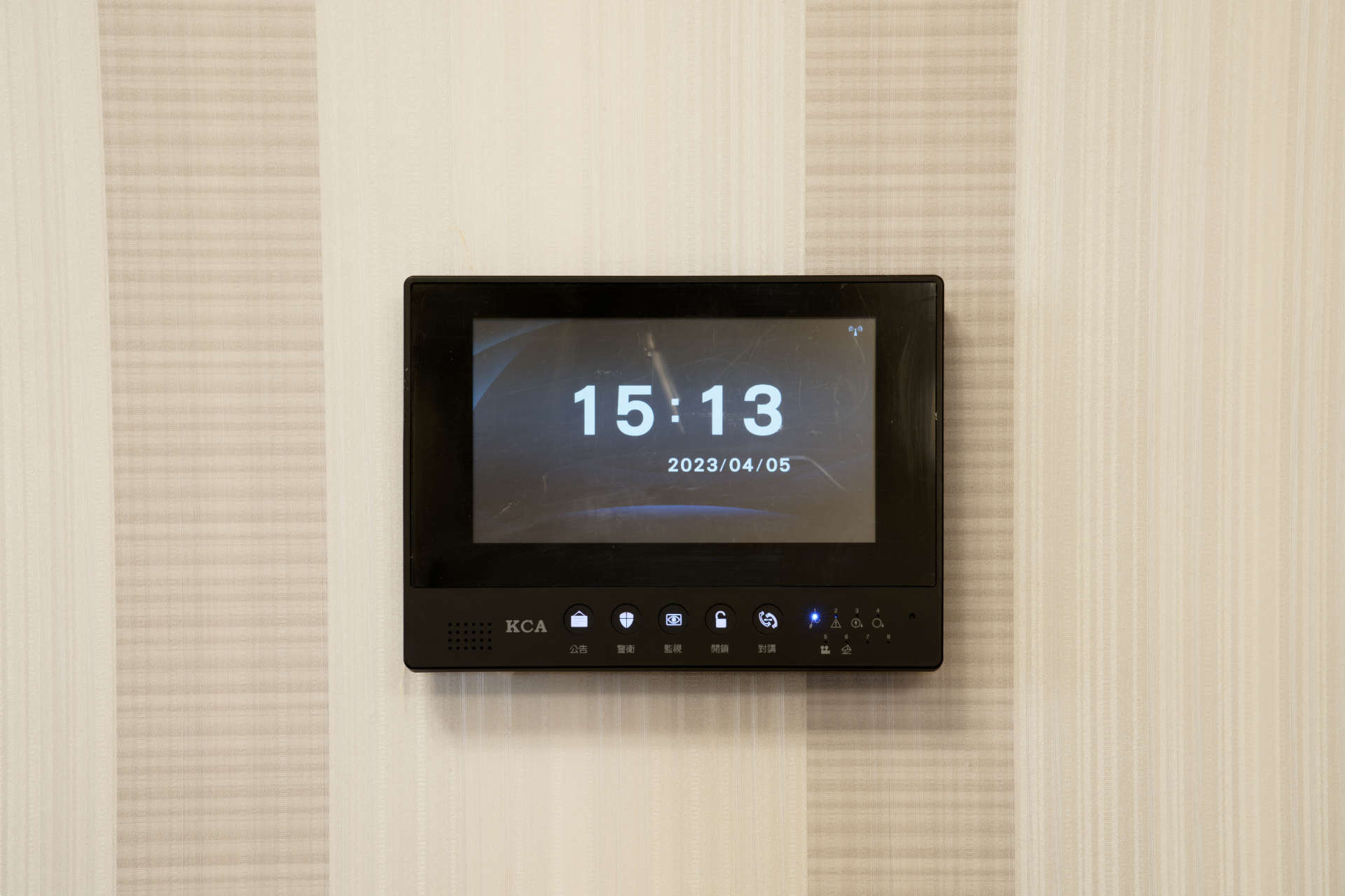 A wall-mounted security monitor displaying the date and time.