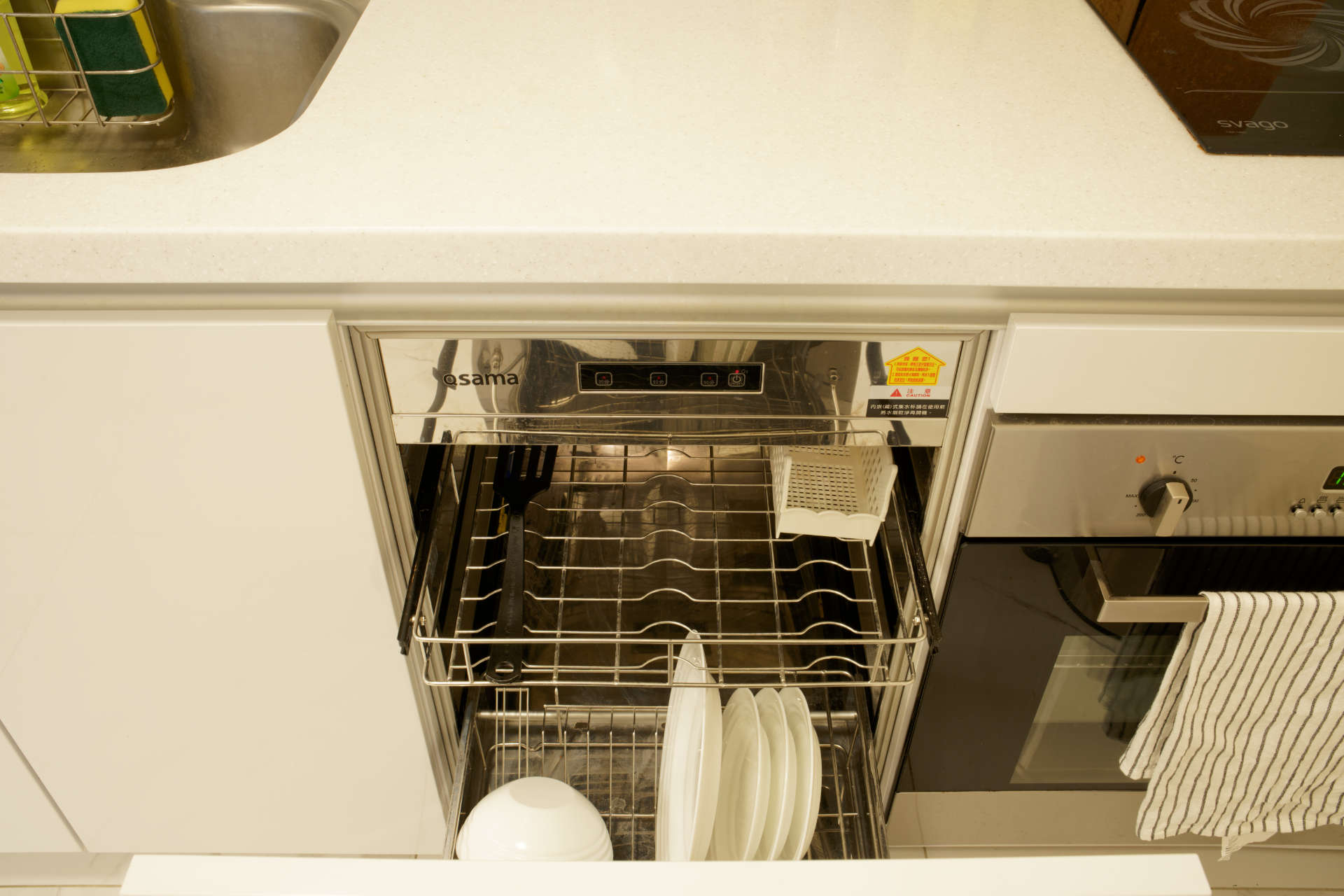 An ope Taiwanese dish dryer/sterilizer, with some plates and a plastic utensil inside.