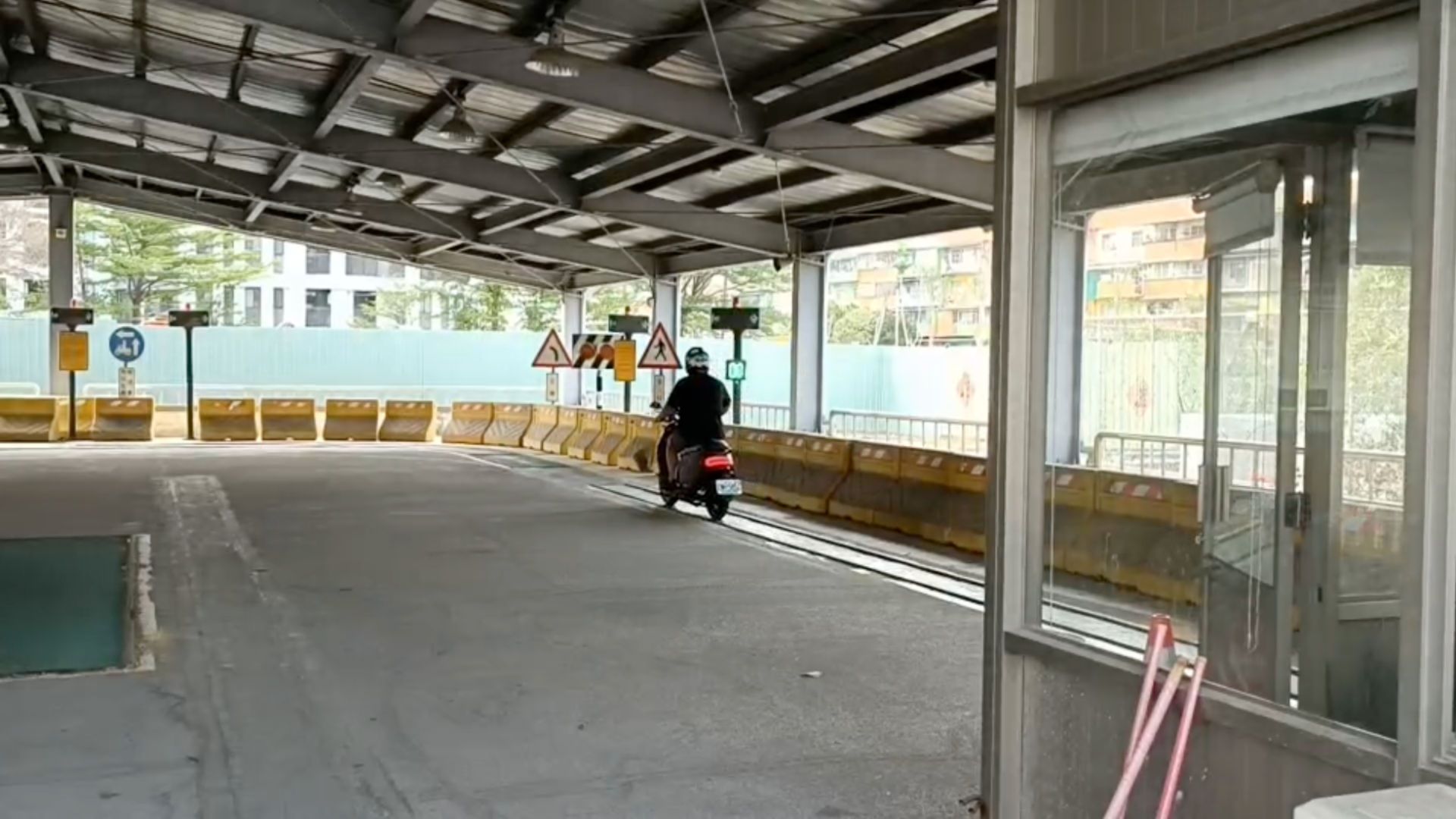 A person driving an electric scooter along a very narrow track at a Taiwan Motorcycle Road Test Site.