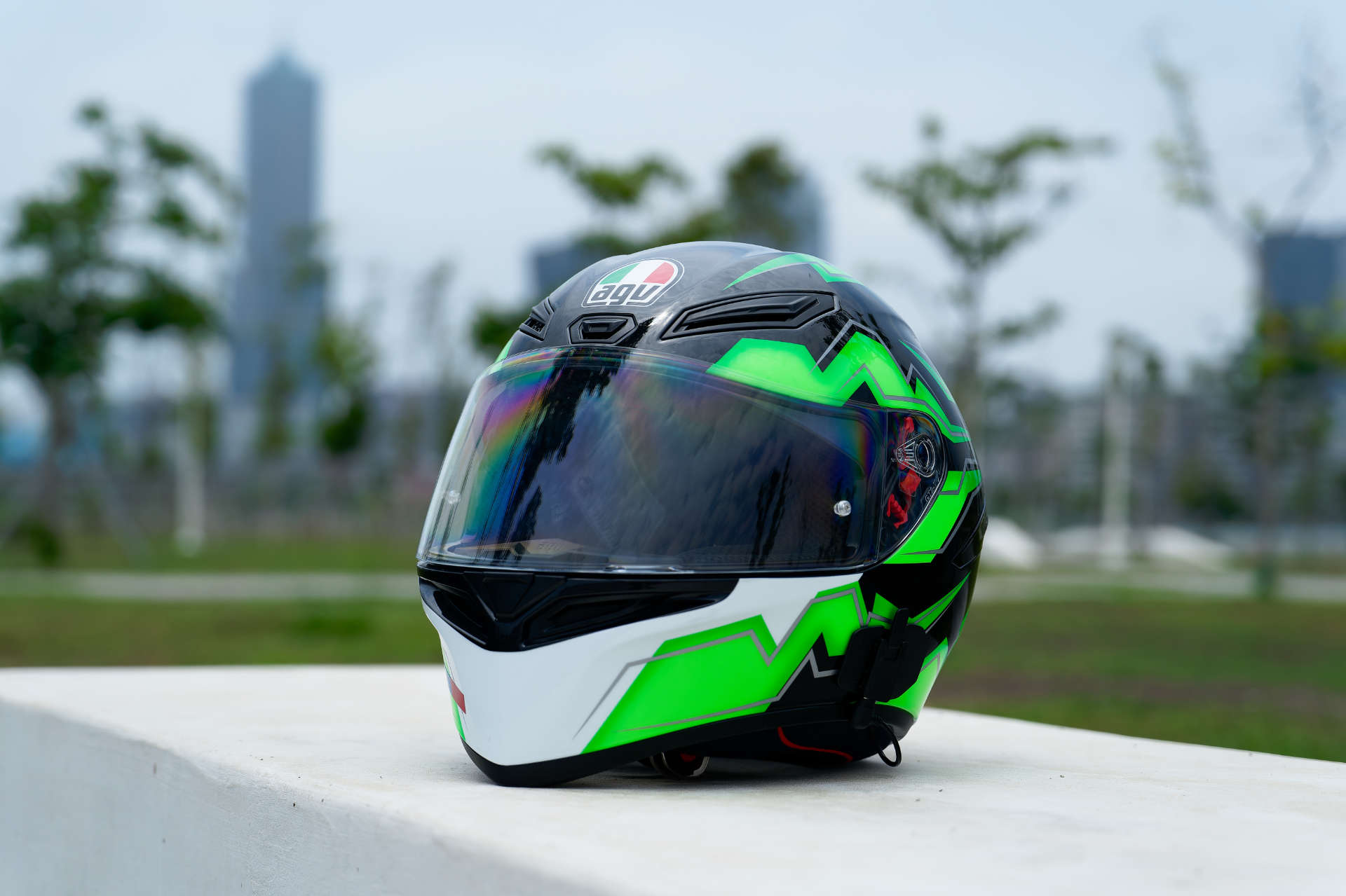 An AGV K1 S full-face motorcycle helmet photographed on a concrete park bench.
