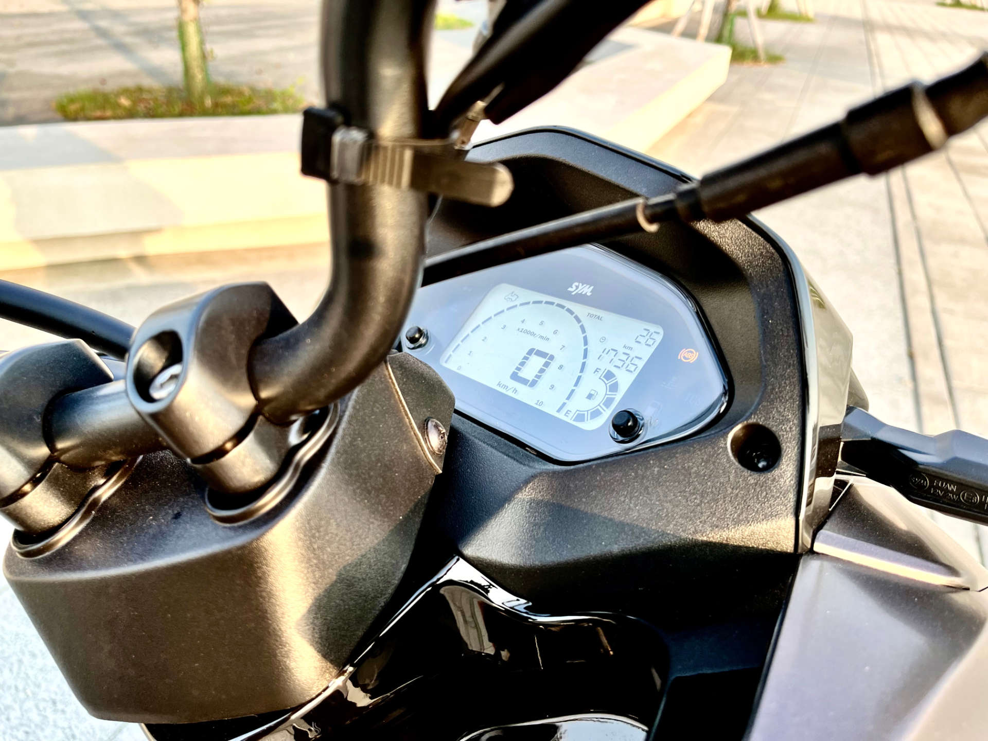 Close-up of the digital dashboard on the SYM MMBCU scooter. It shows 26km on the odometer, a time of 17:36, and a full tank of fuel.