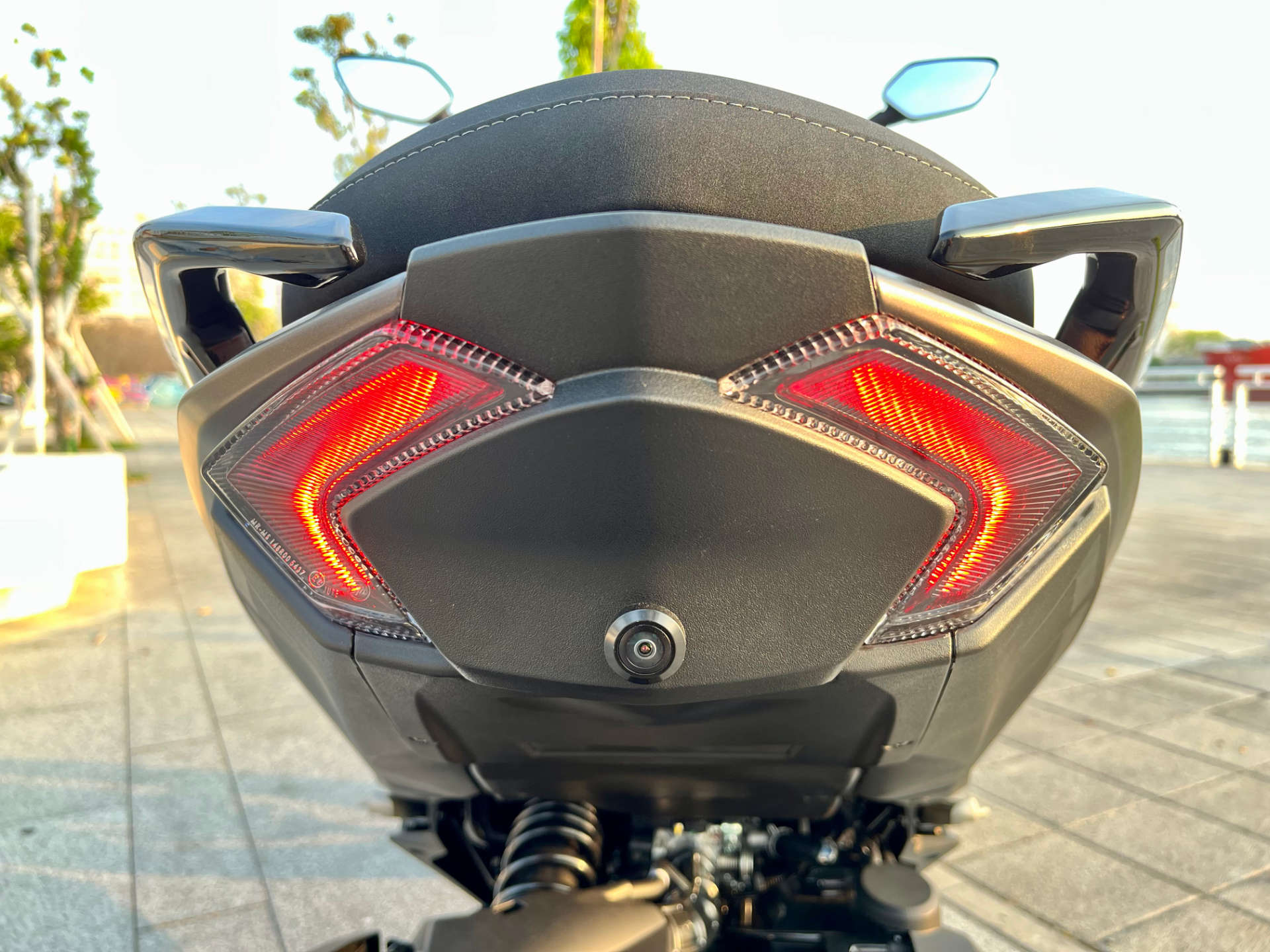 Close-up of the rear dashcam camera and rear lights on an SYM MMBCU scooter.