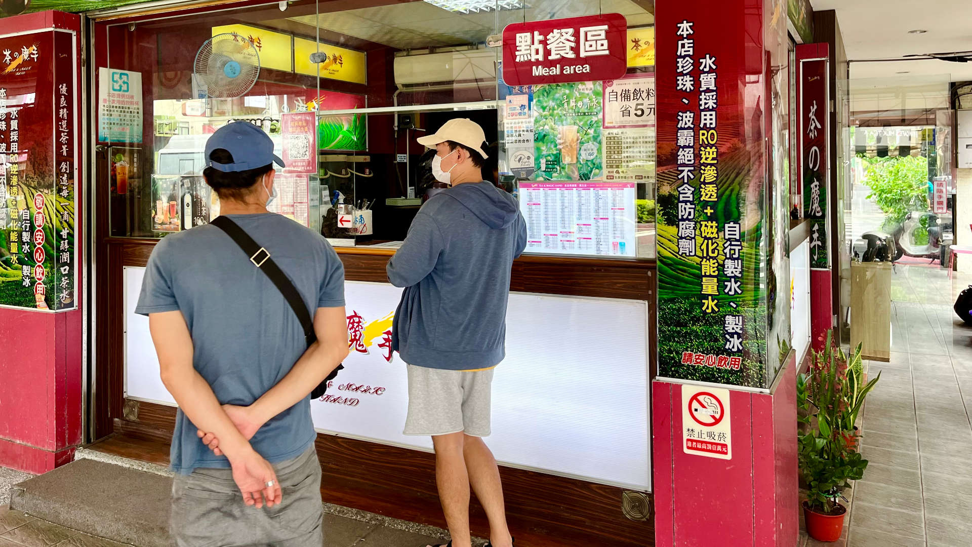 Customers standing outside a take-away tea shop in Kaoshiung, Taiwan.