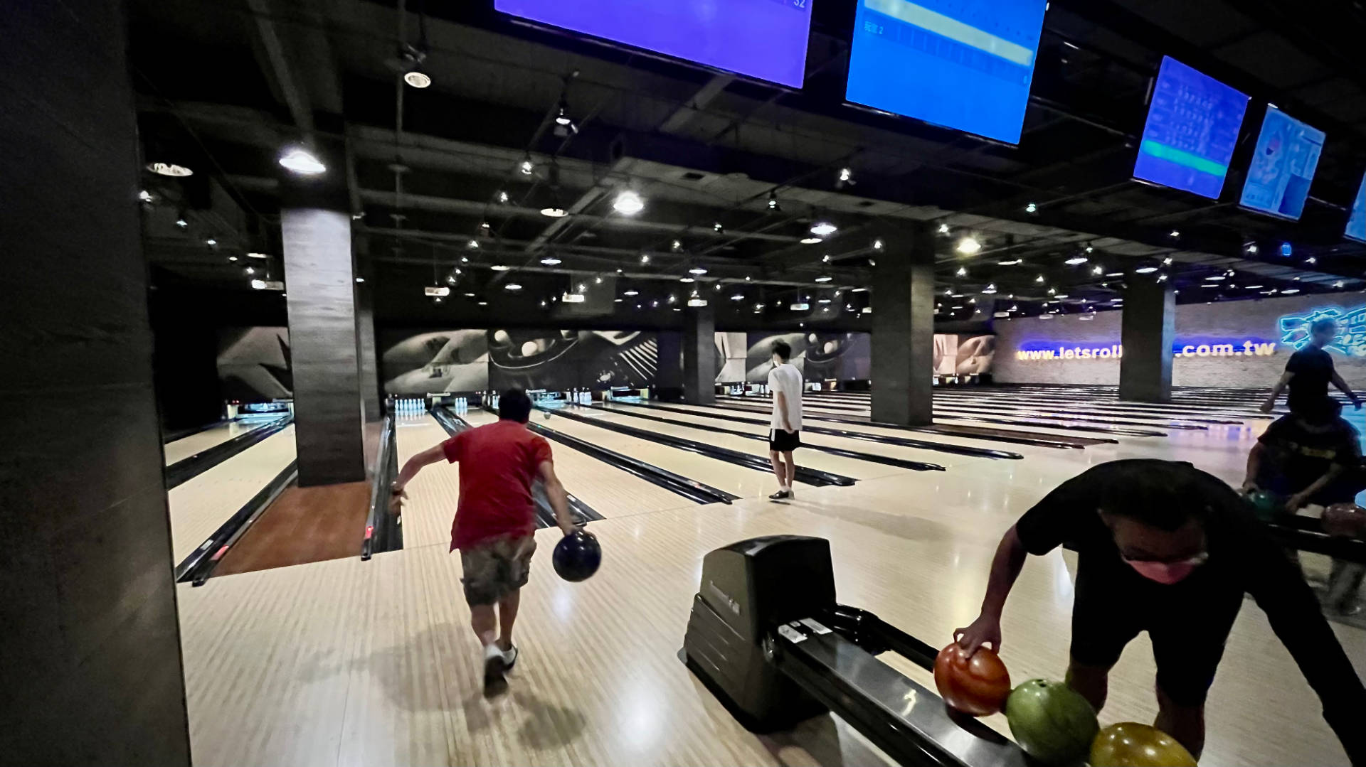 Inside a 10-pin bowling alley. The room and the bowling balls are spotlessly clean.
