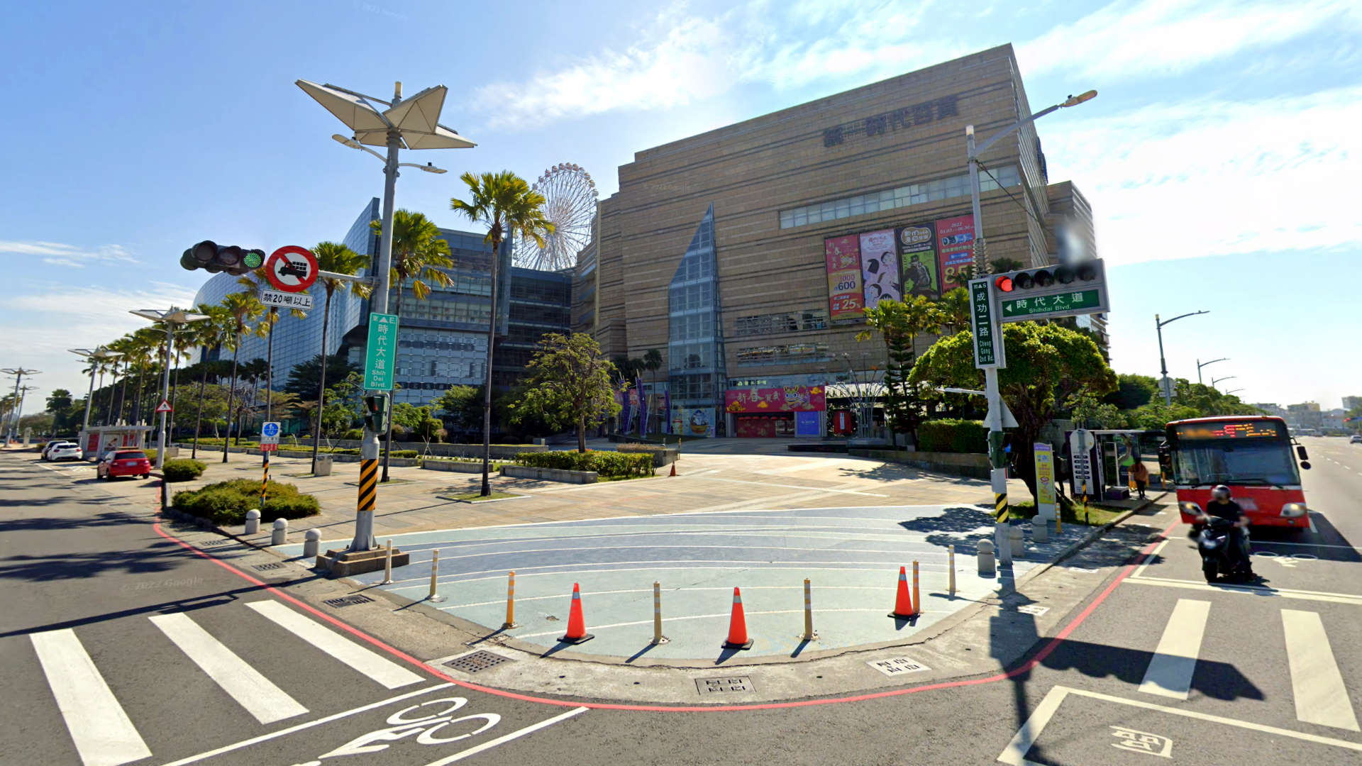 Daytime photo of the entrance to Dream Mall. It is a large building with a ferris wheel on the roof.