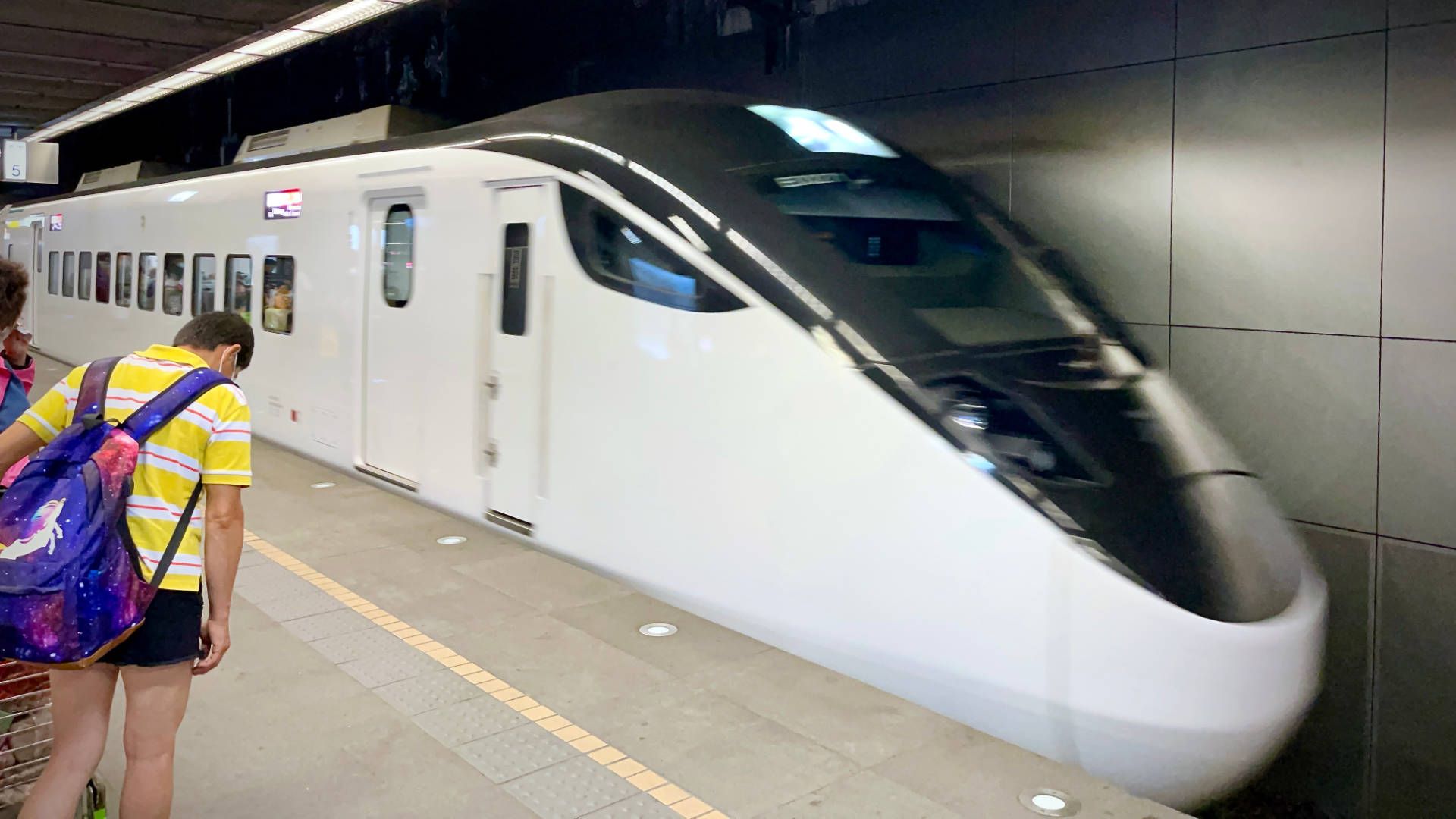 A sleek-looking train arriving at an underground platform.