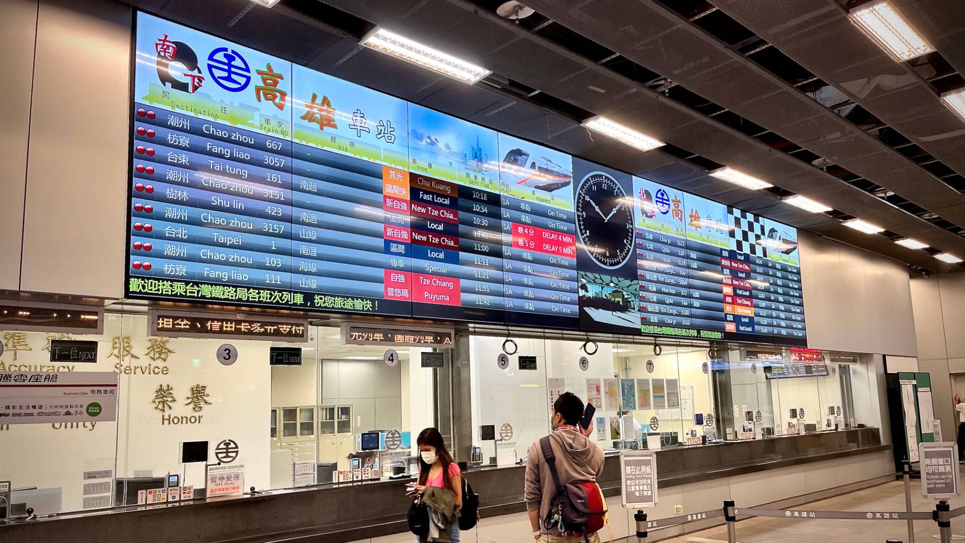 A large electronic departures board above the ticketing office.