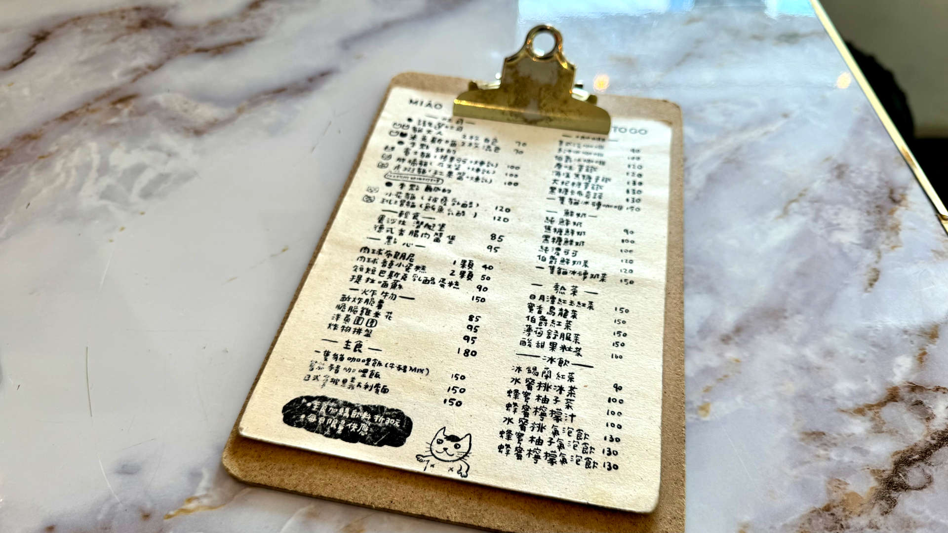 A hand-written menu on a clipboard. The writing is all Chinese.
