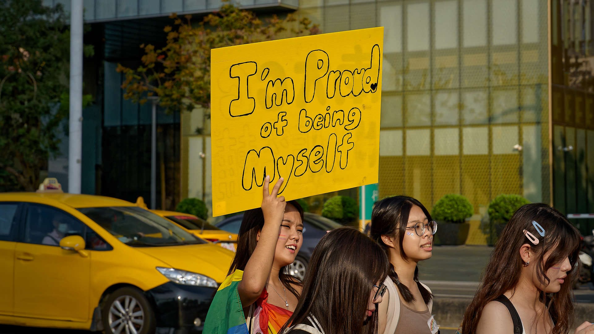Woman holding a sign that says “I’m proud of being myself”.