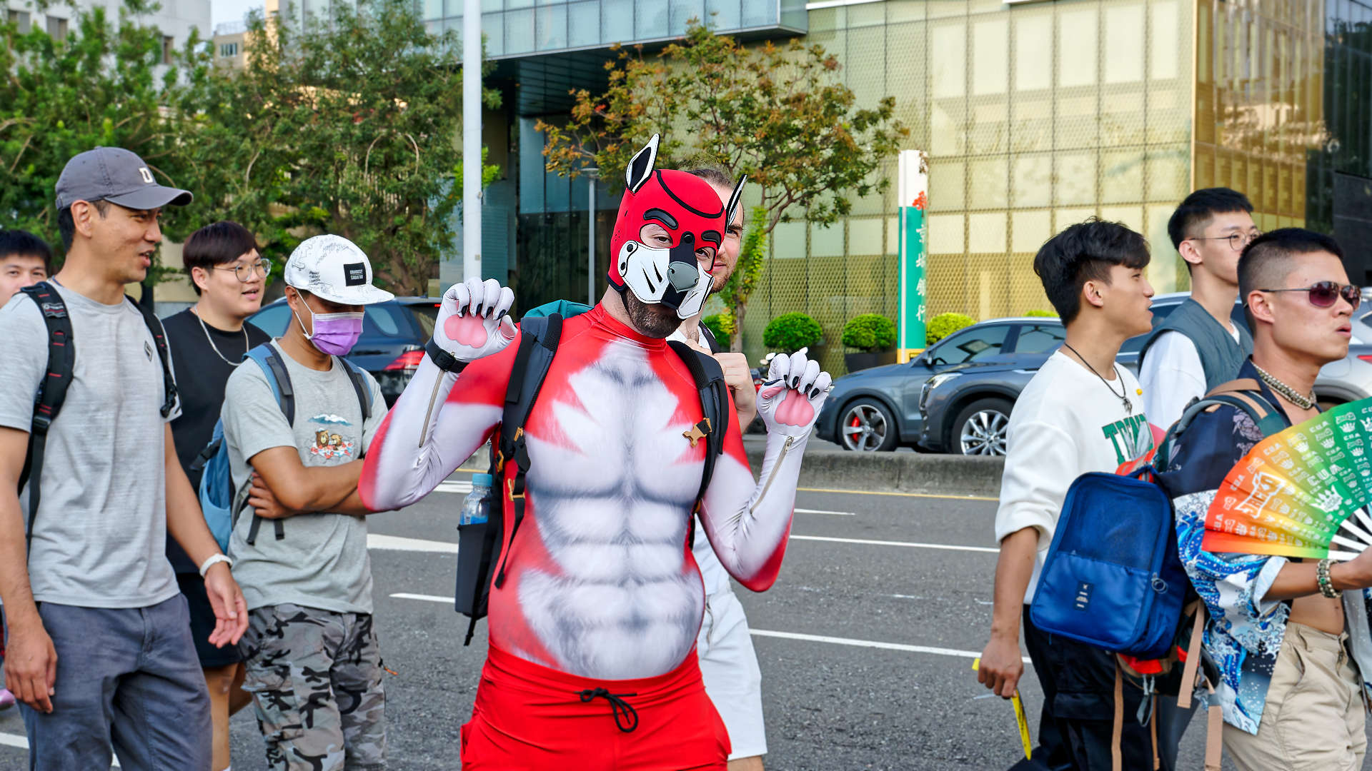 Man dressed as a red pup, posing for the camera.