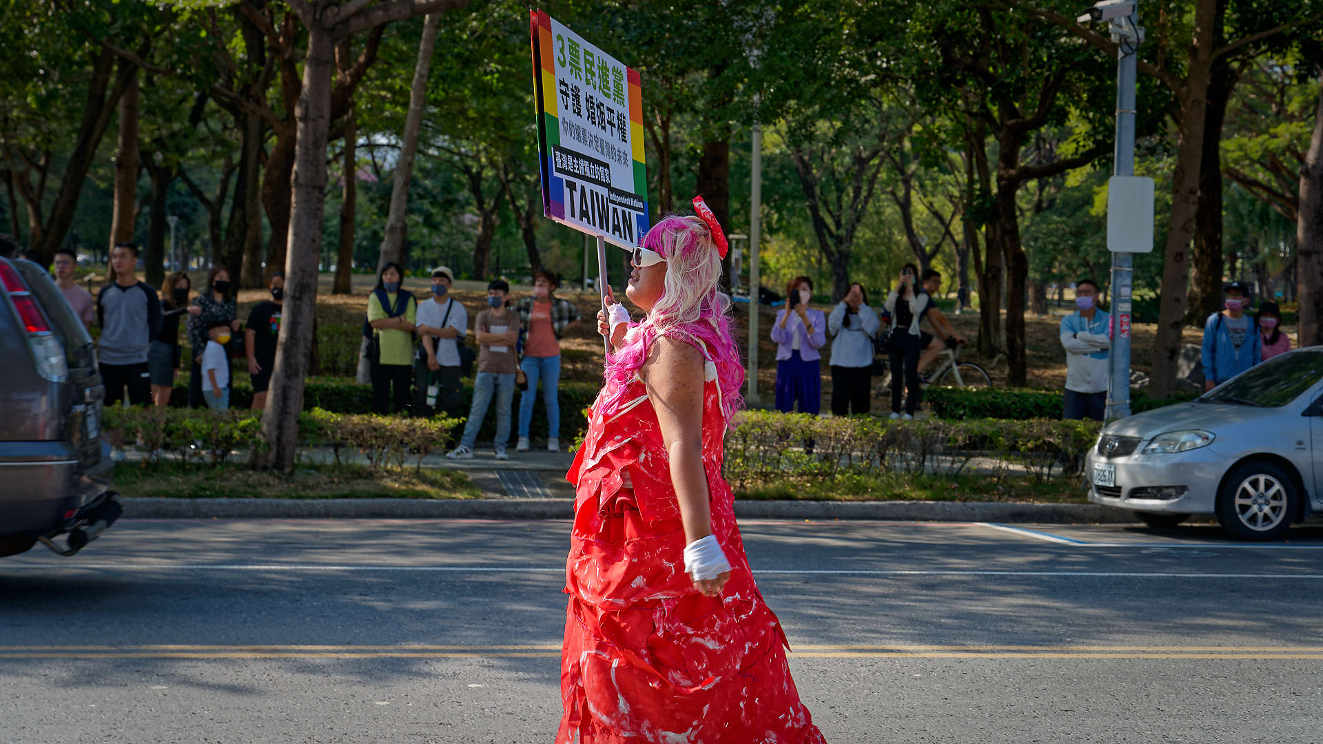 Person walking alone, holding a protest sign about “Independent nation Taiwan”.