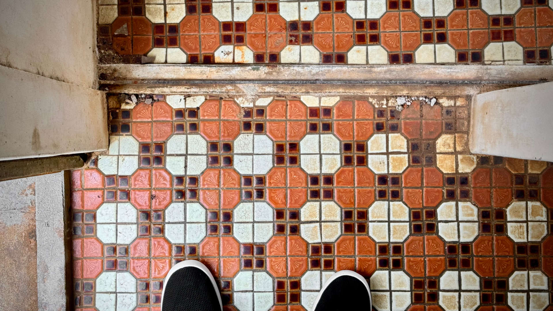 A slightly-crooked tiled floor in an abandoned building.