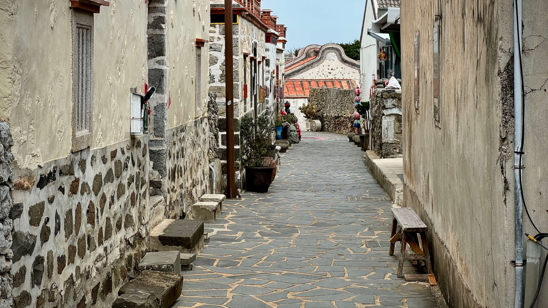 An alleyway in Erkan Historic Village. There are historic stone buildings on either side.