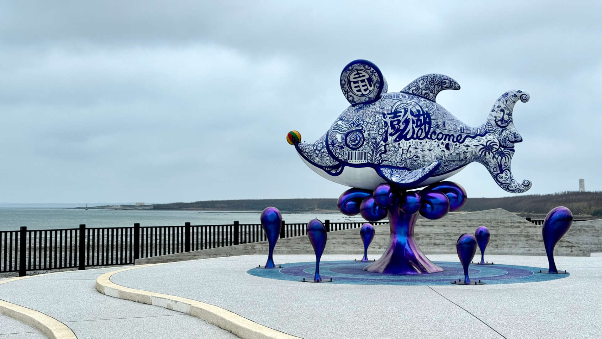 A fish statue at the seaside, facing out to sea, with the word ‘welcome’ on its side.