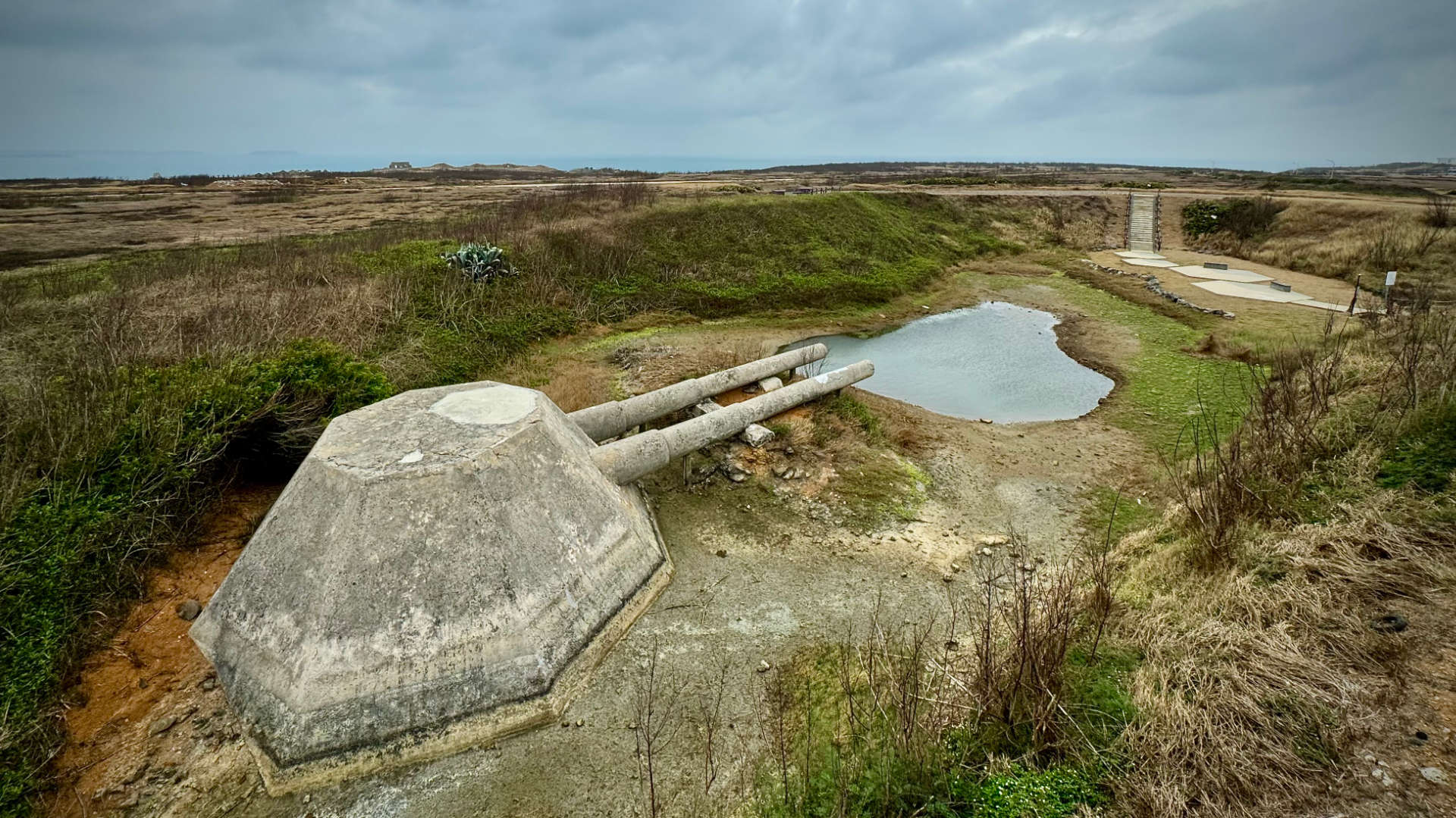 The Wai-An Fake Cannon, a large cannon-like shape made of concrete built in a hollow on a flat plateau.