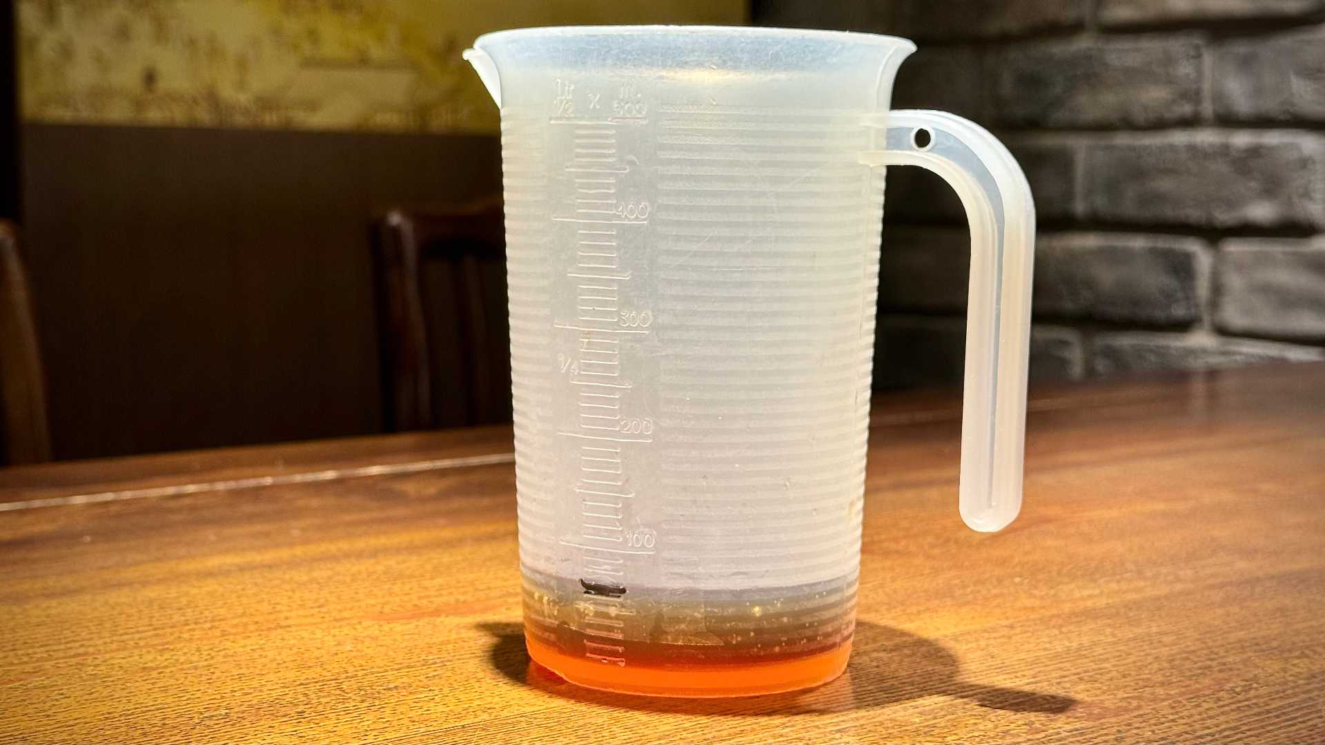 A plastic measuring jug containing 70mL of black tea.