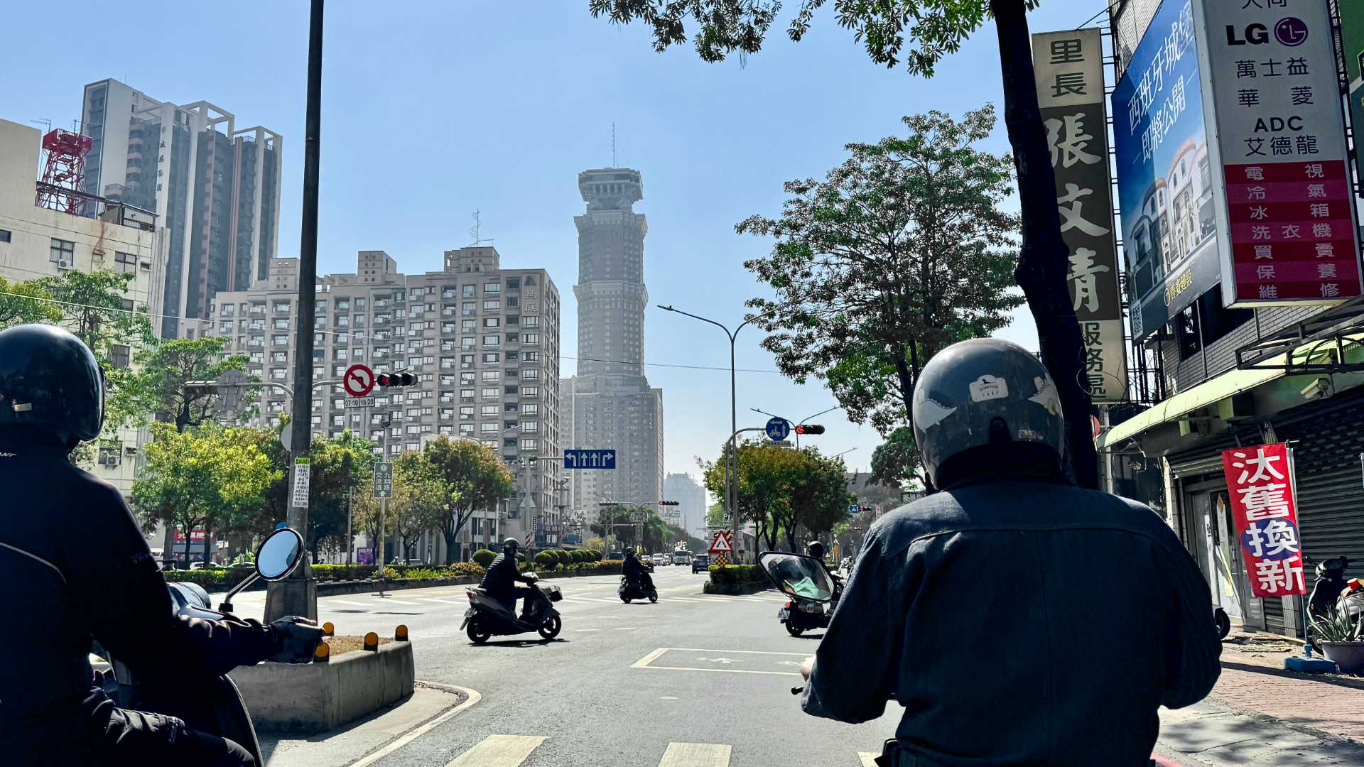 A point-of-view shot of Chang-Gu World Trade Center in Kaohsiung, Taiwan, taken while on a motorcycle at a red traffic light.