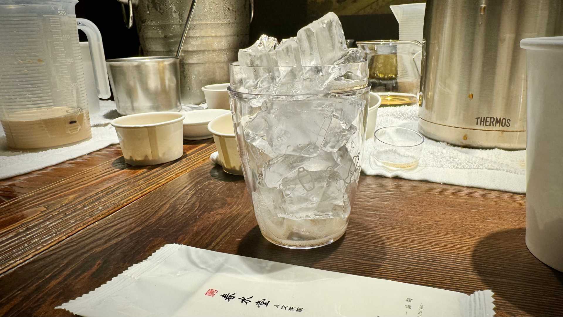 A transparent plastic cocktail shaker filled with ice.