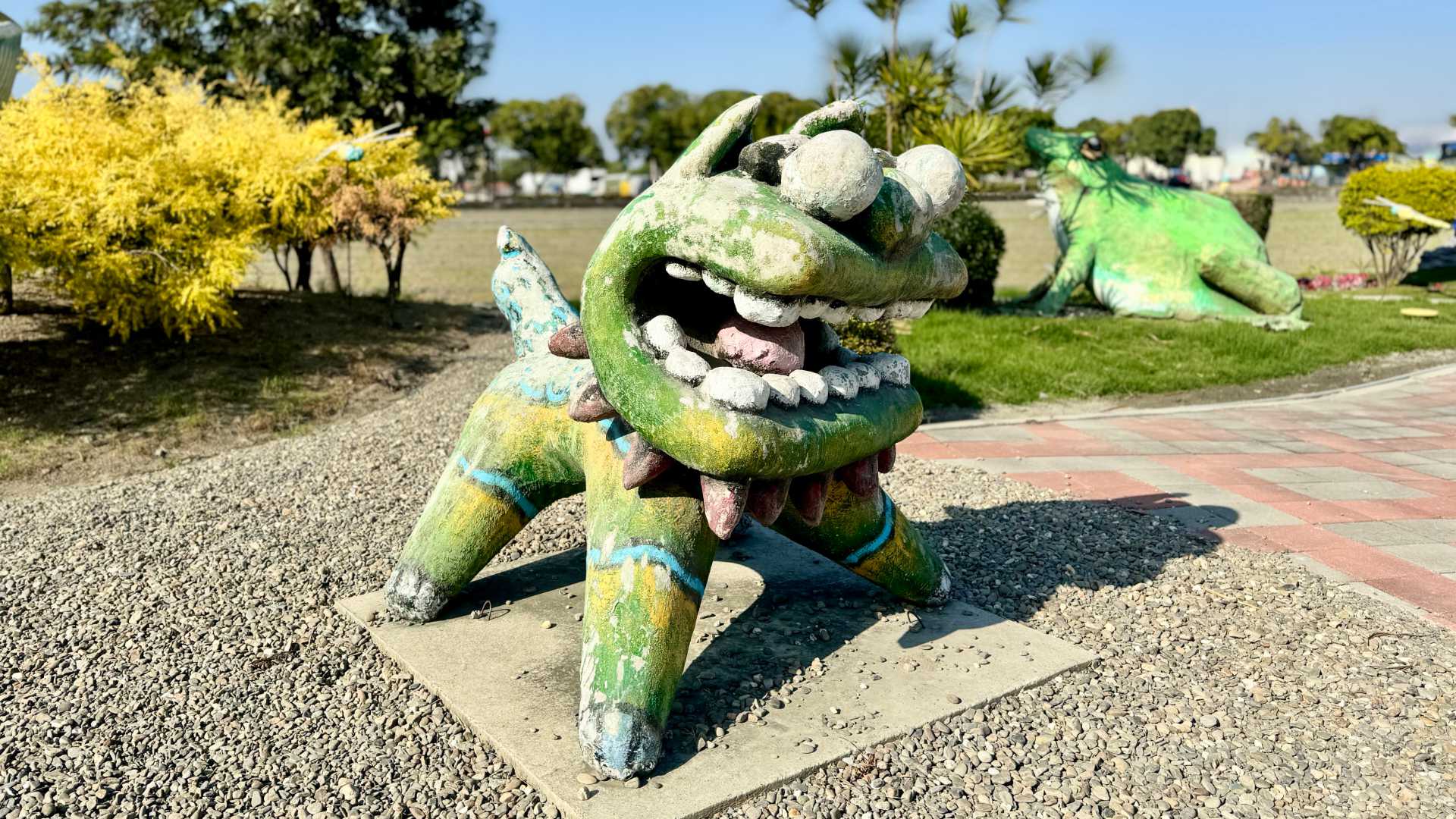 A concrete Chinese lion in the foreground, and a concrete frog in the background. Each is about 1 meter tall.