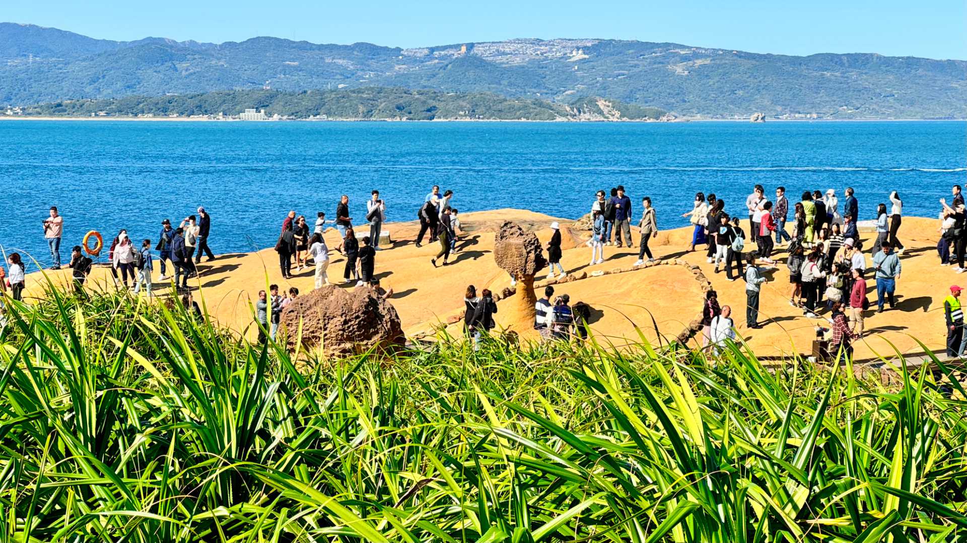 A wide-angle shot of dozens of people around Queen’s Head Rock in New Taipei, Taiwan.