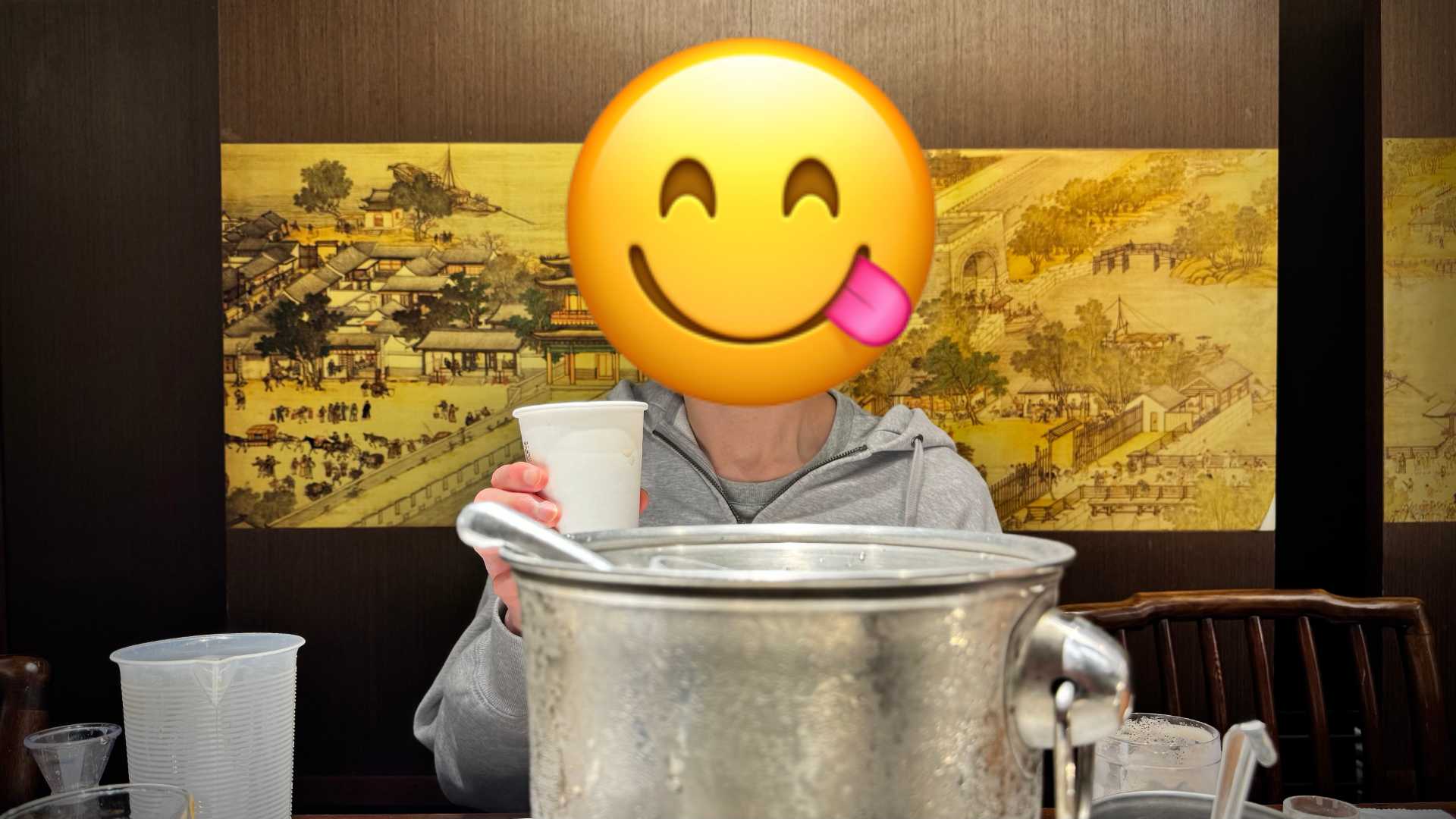 A person enjoying a cup of black tea. Their face is obscured by a licking-lips emoji.