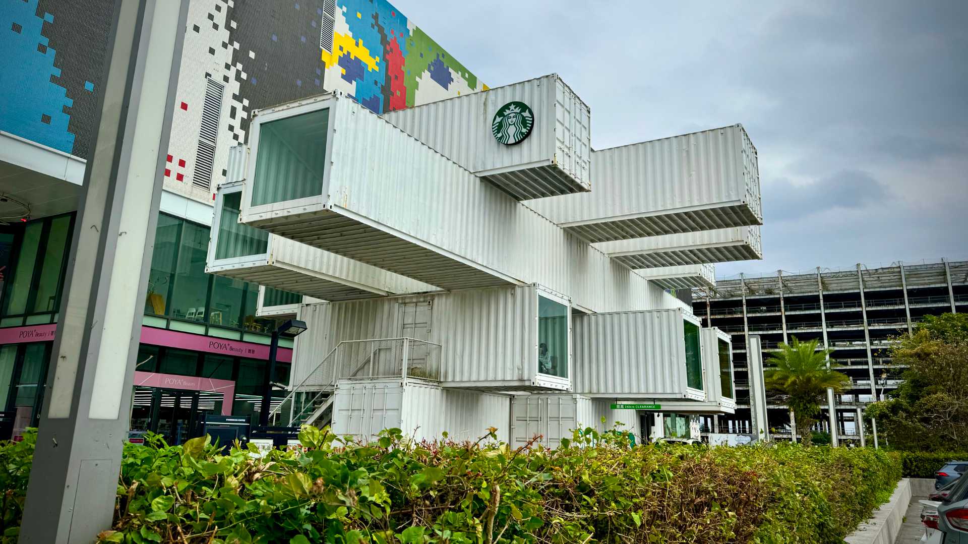 A Starbucks building made of four stories of stacked shipping containers projecting outwards at right angles.