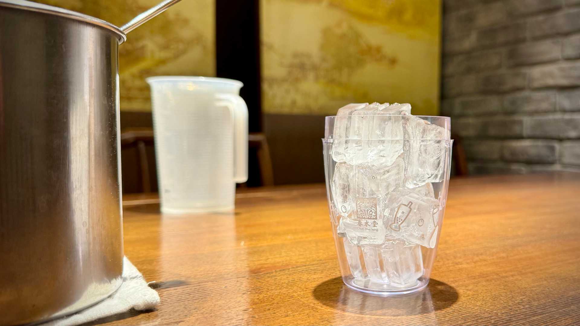 A transparent plastic cocktail shaker filled with ice.