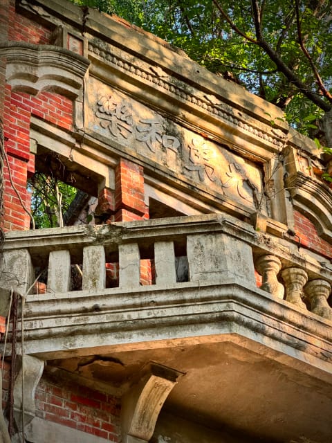 The third-floor balcony of Minxiong Haunted House, with an inscription in the concrete above the balcony. The inscription comprisses four Chinese characters.