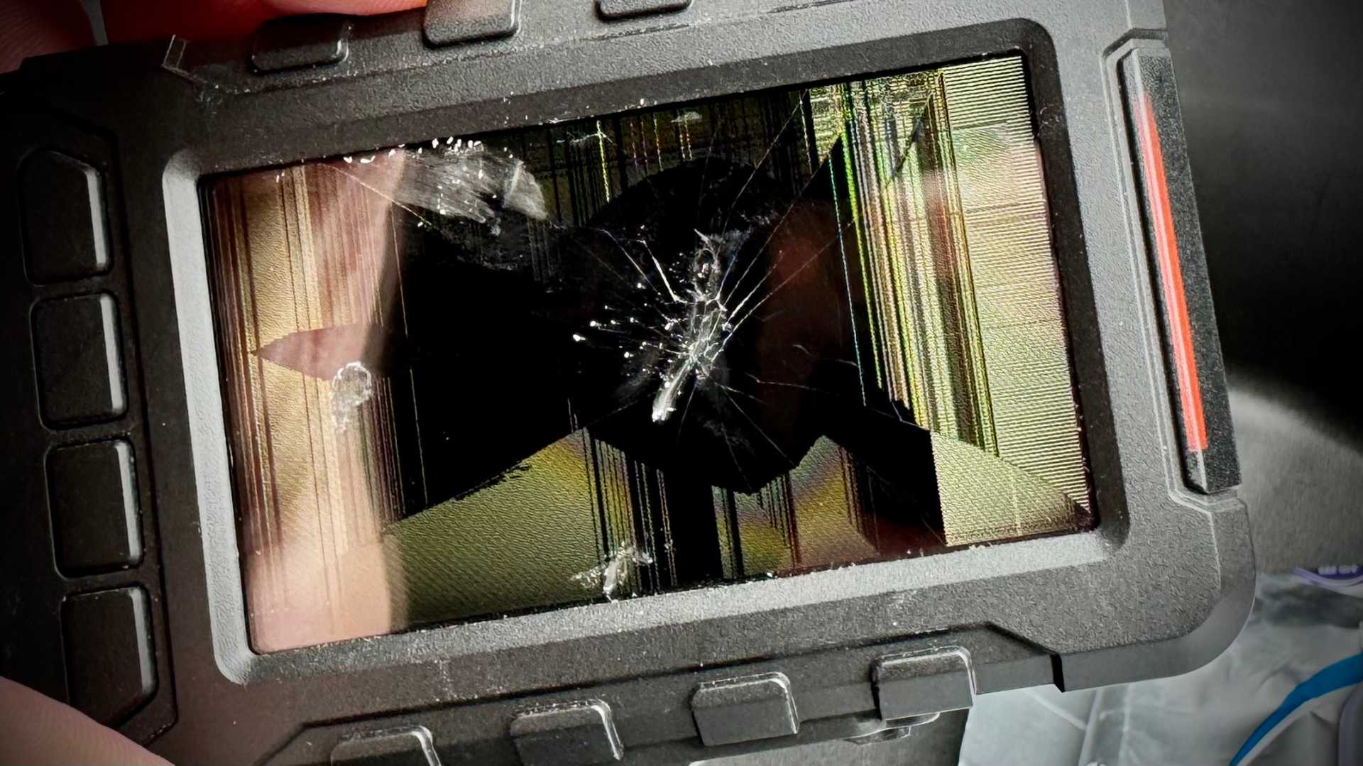 A motorcycle dashcam recording module with a smashed screen.